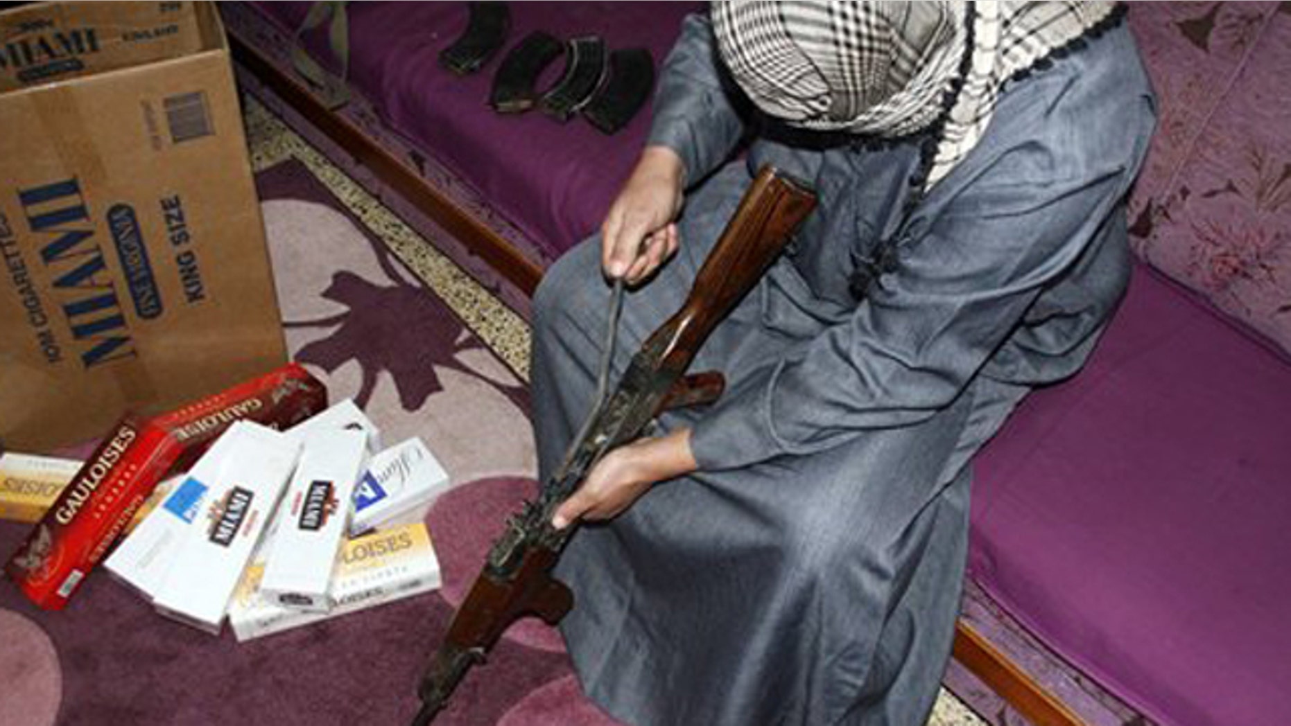 Feb. 14, 2012: Iraqi smuggler Younis al-Lehaibi, 46, dismantles an AK-47 machine-gun at his house.
