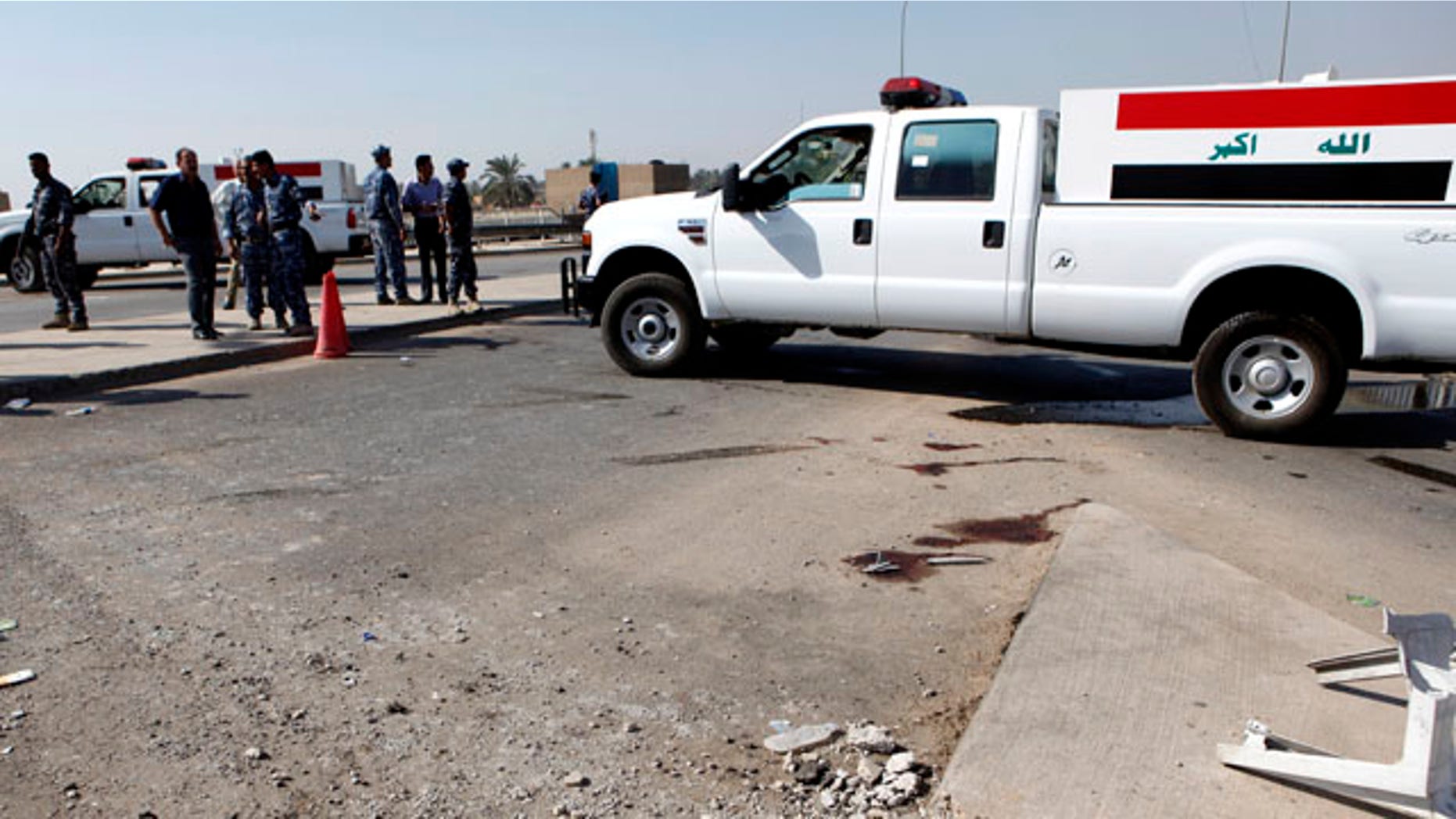 Oct. 27, 2010: Iraqi security forces inspect the scene of a roadside bomb, which exploded in northern Baghdad, Iraq, Wednesday. Iraqi police say a bombing at a checkpoint near the headquarters of a Sunni foundation in north Baghdad has killed security guards.
