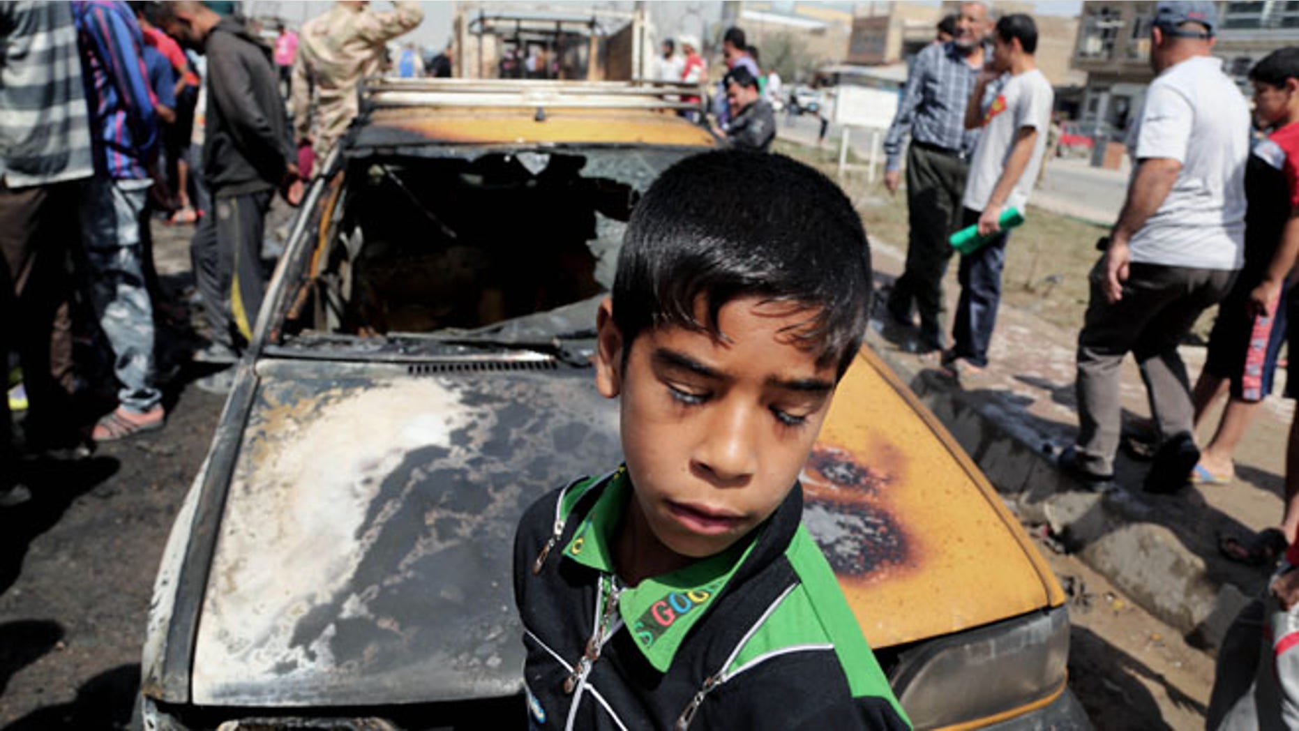 April 9, 2014: Civilians inspect the site of a car bomb attack in Baghdad's Sadr City neighborhood, Iraq.