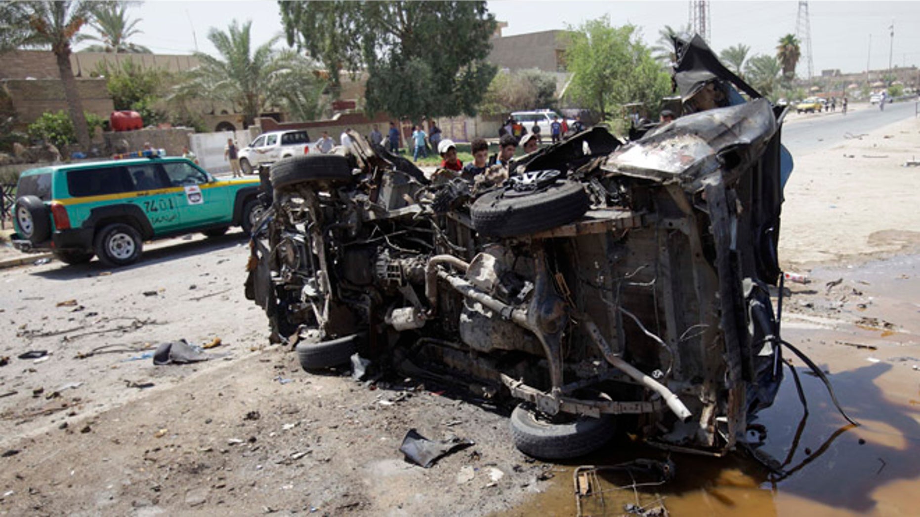 Aug. 15, 2013: Civilians inspect the aftermath of a car bomb attack in Baghdad, Iraq.
