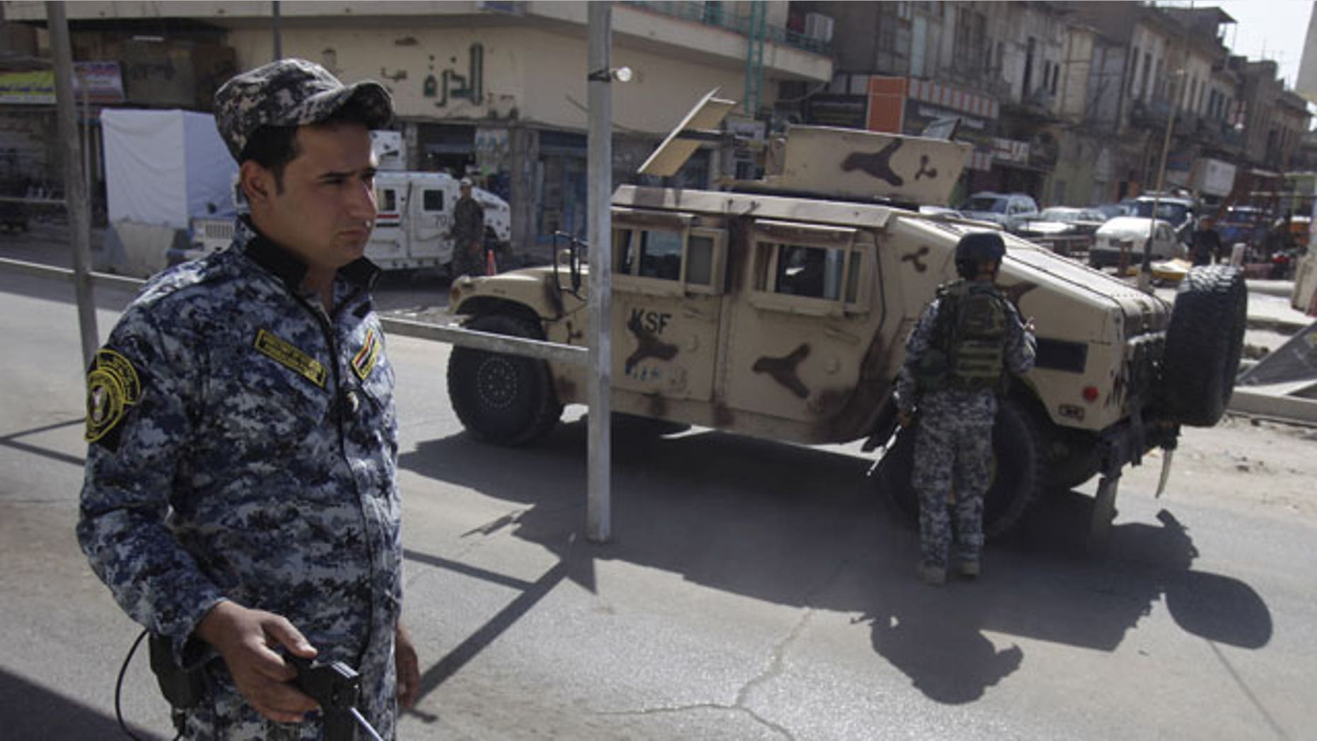 October 23: An Iraqi police officer uses a detector at a checkpoint in central Baghdad, Iraq.