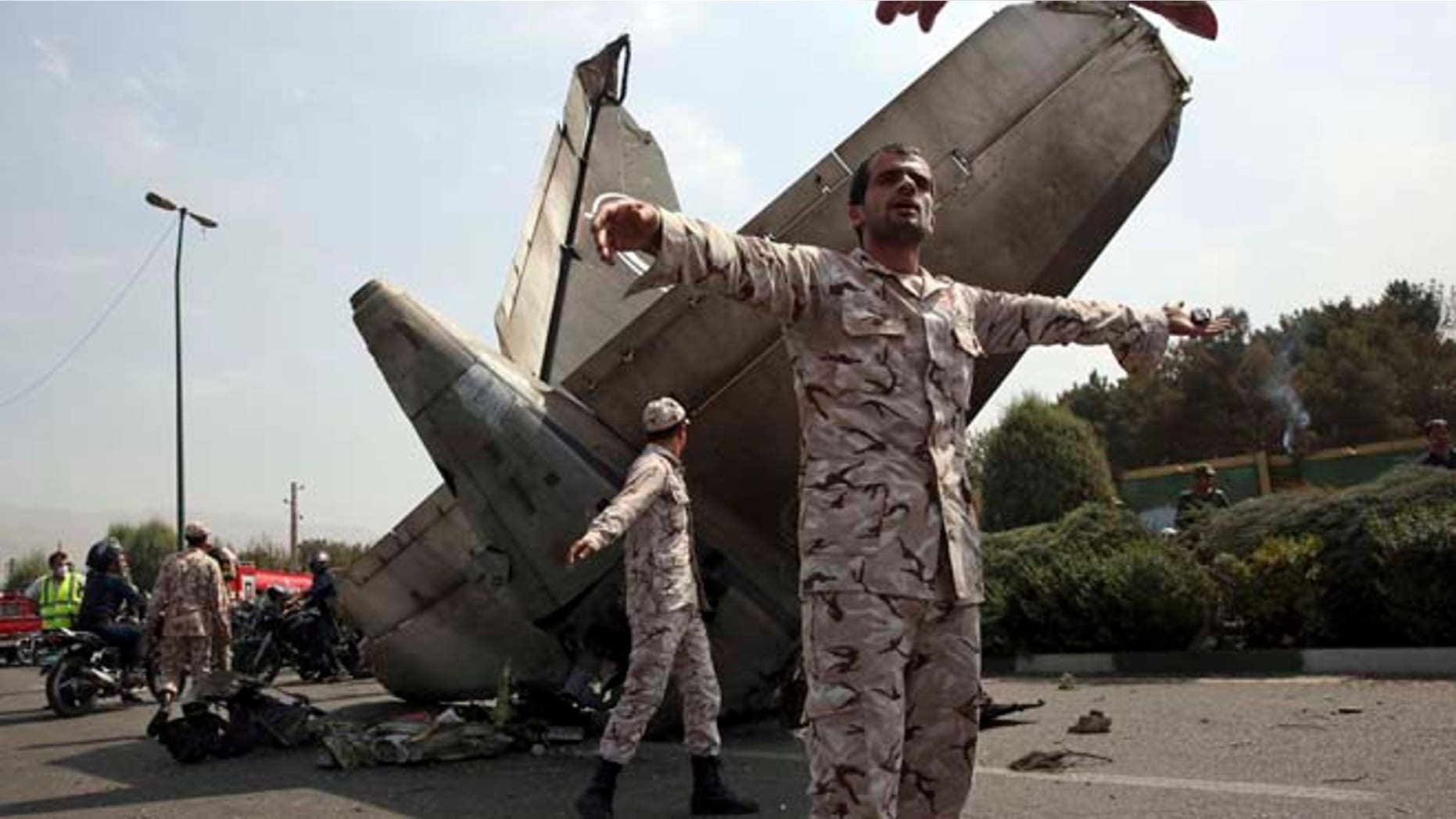 Aug. 10, 2014: Iranian Revolutionary Guards prevent the media from approaching the wreckage of a passenger plane crash near the capital Tehran, Iran. (AP)