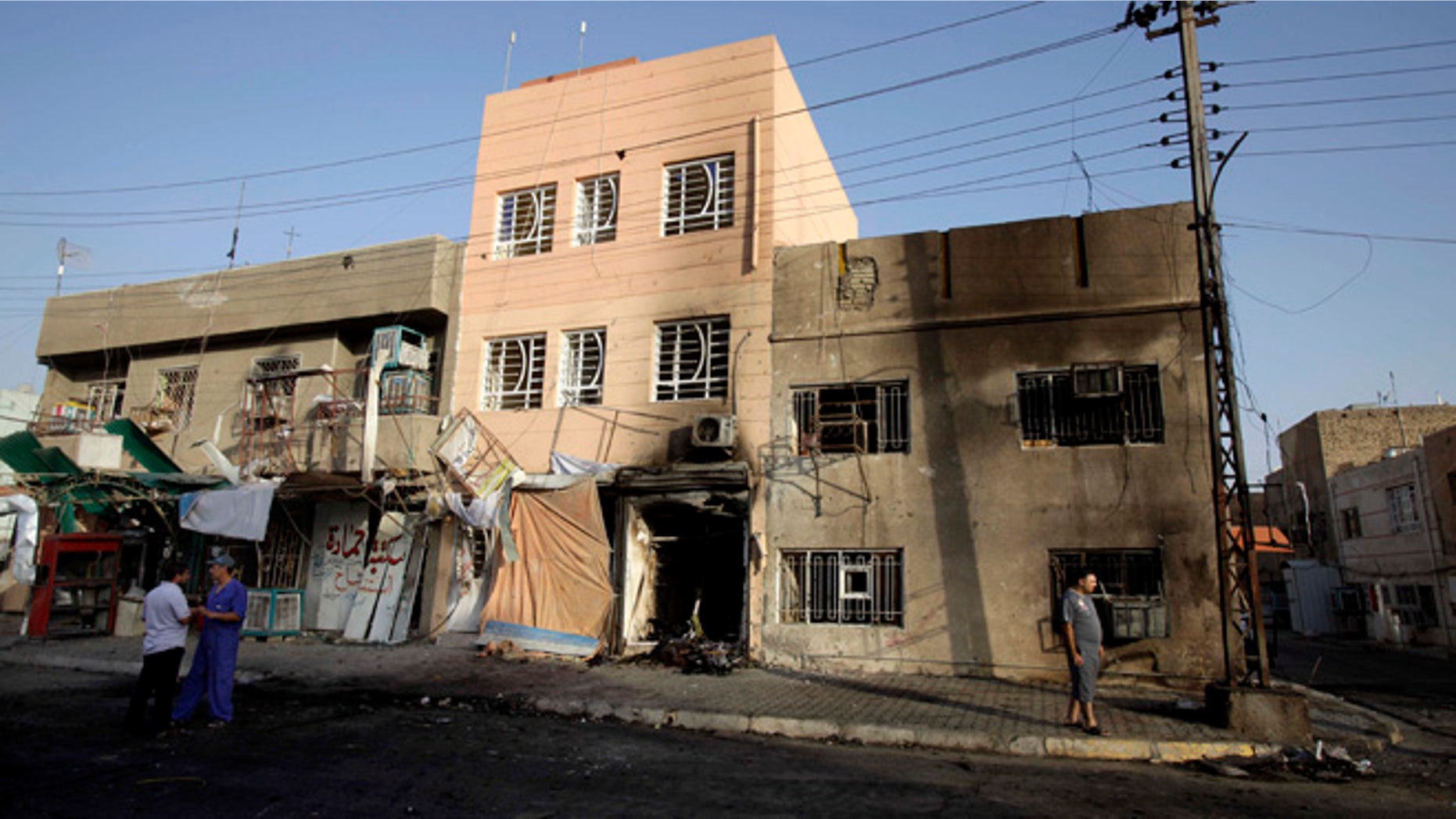 July 21, 2013: Civilians inspect the aftermath of a car bomb attack in the neighborhood of Tobjee in Baghdad, Iraq.