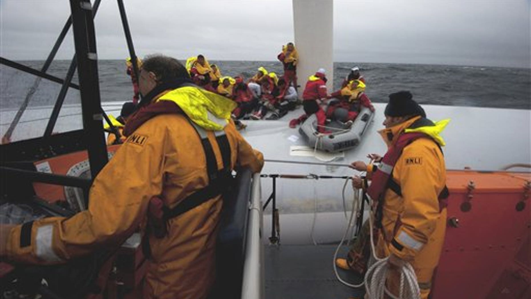 Aug. 15: This image made available by the Royal National Lifeboat Institute shows the Baltimore, Ireland, RNLI lifeboat crew taking part in a major rescue operation Monday evening, as a member of the yacht's crew is placed in a dingy on the yacht's upturned hull for transfer to the lifeboat. British sea rescue workers say that 21 people were rescued after their U.S.-registered racing yacht capsized off the Irish coast.