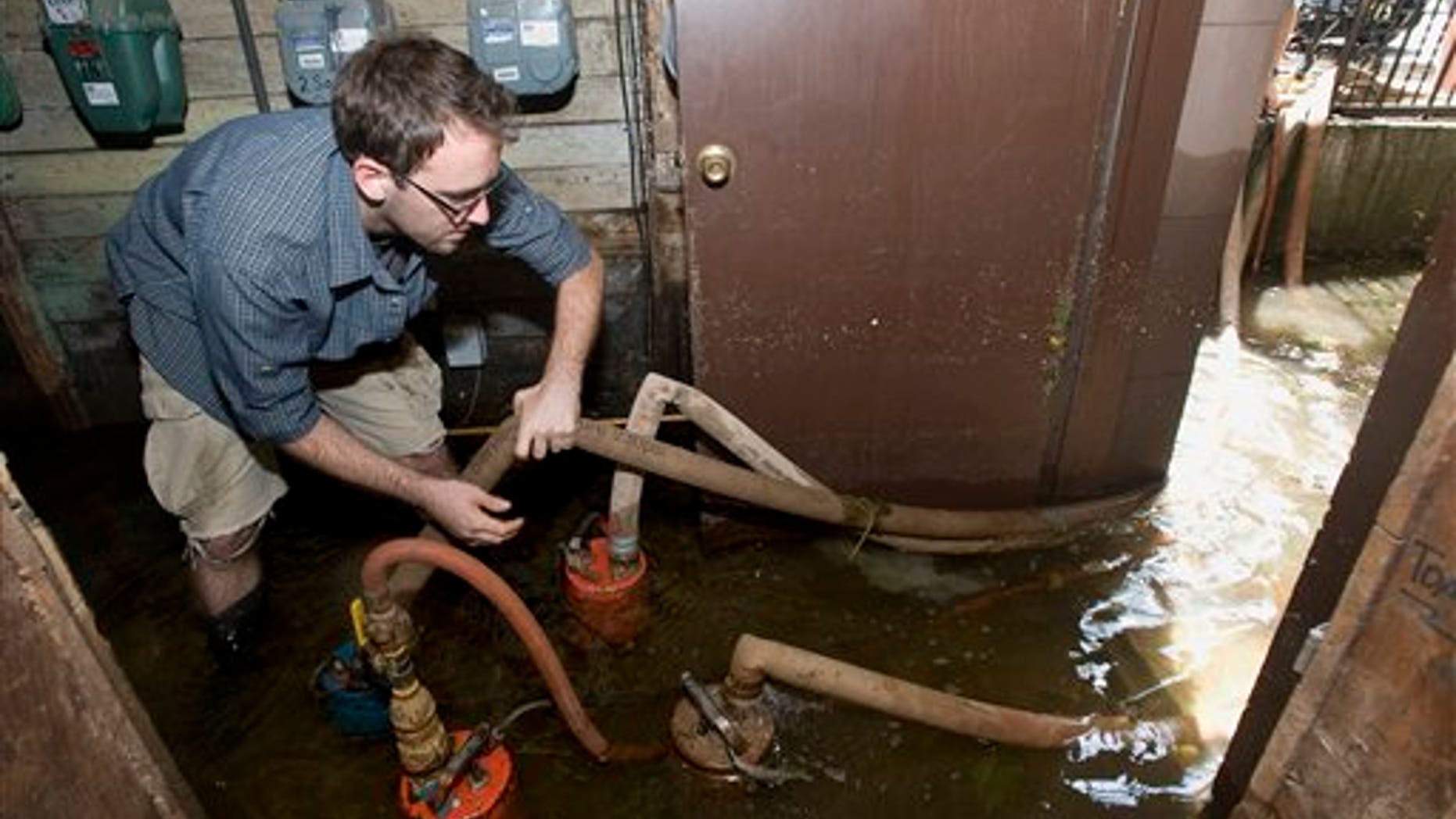 Aug. 29: Matt Pelmear of Hoboken, N.J. adjusts the hose on one of four pumps he was using to remove several feet of water from the basement of the building he lives in on Adams Street, in the wake of Tropical Storm Irene, in Hoboken. The building was without electricity for part of the day Sunday, and the gas remains shut off.