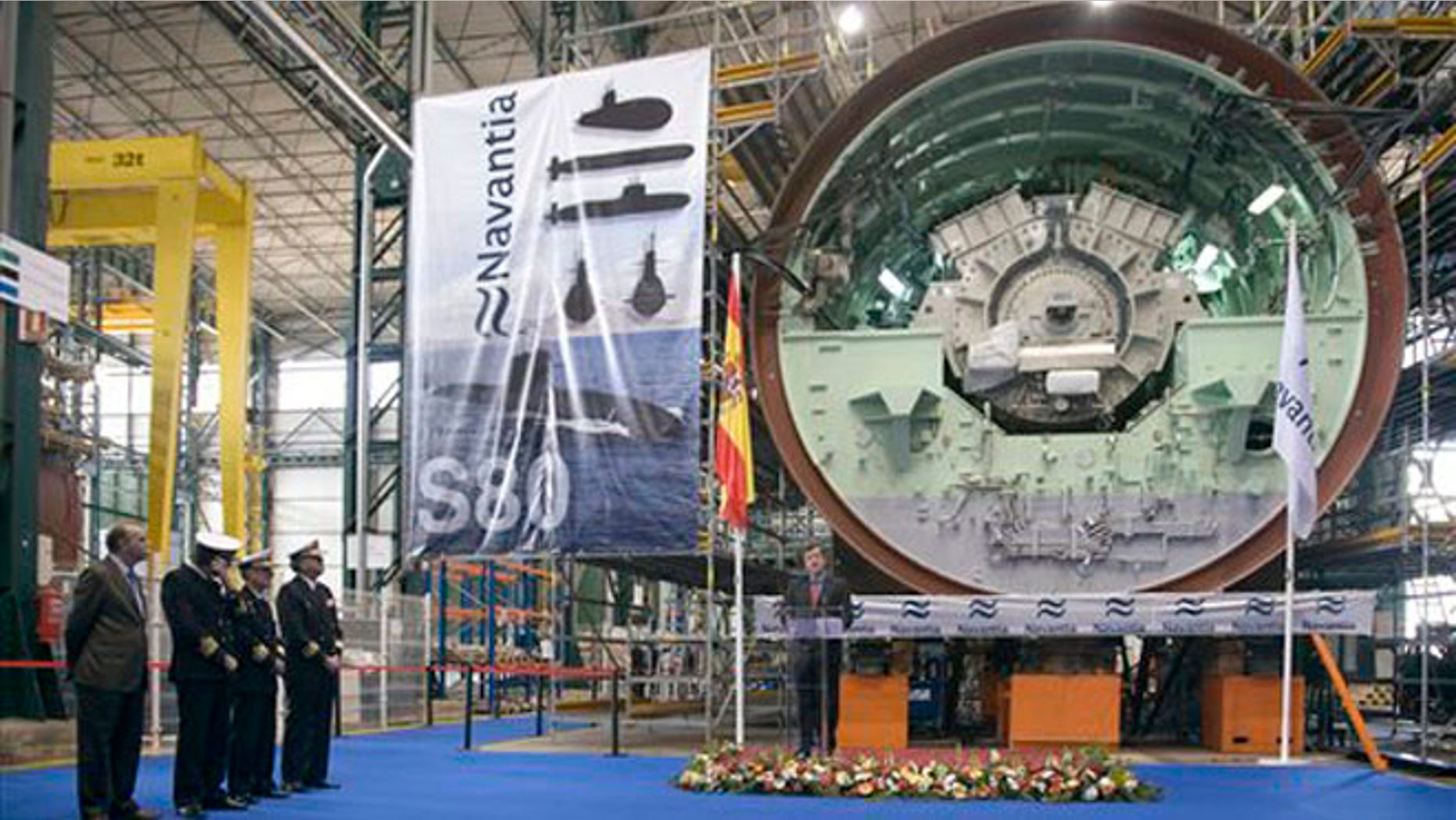 In this Nov. 8, 2012 photo provided by Navantia, Manuel Filgueiras, center, former Cartagena shipyards director, speaks next to the motor of one of the S-80 class submarines in Cartagena, Spain.