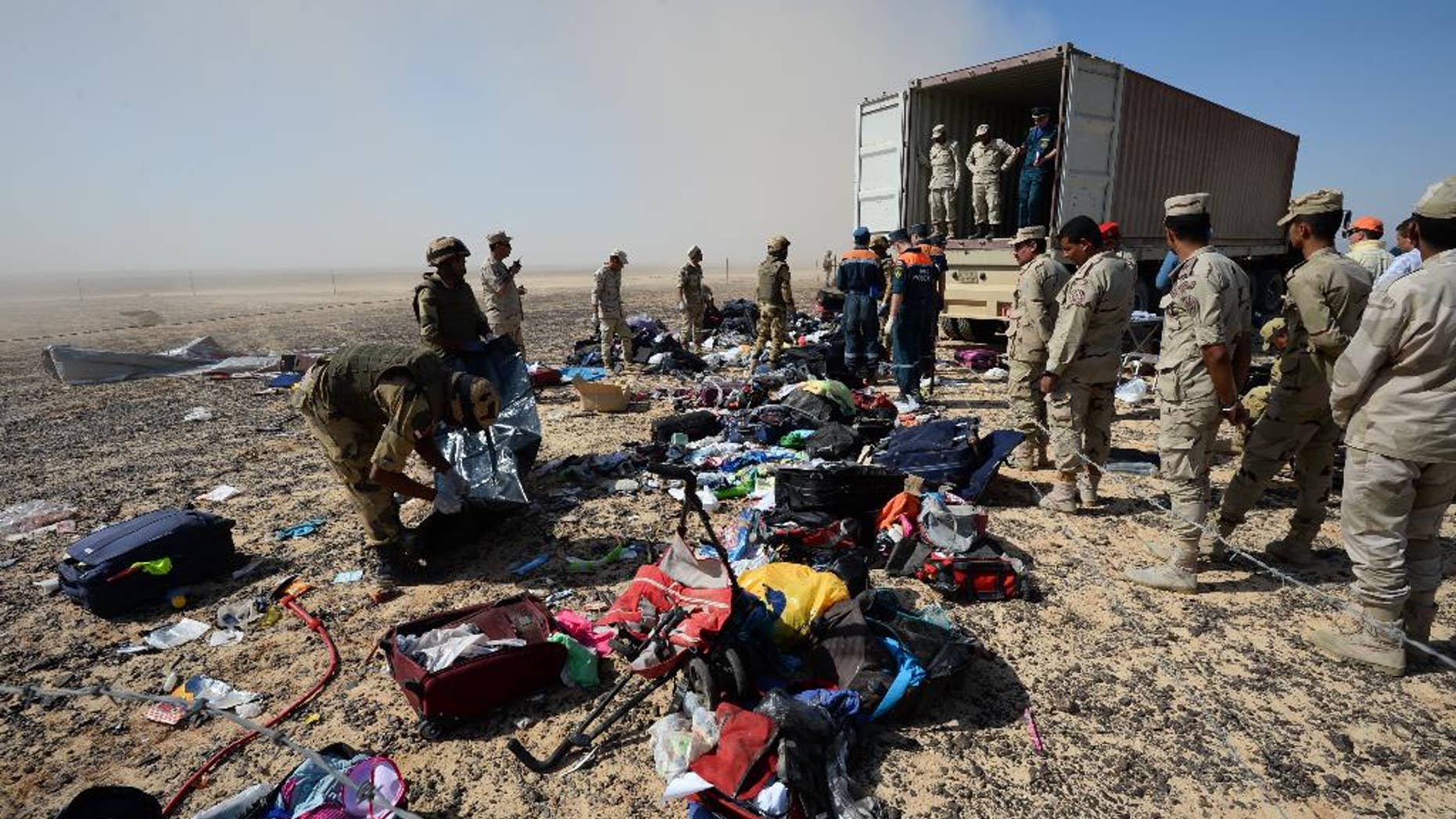 FILE - In this Monday, Nov. 2, 2015 file photo provided by the Russian Ministry for Emergency Situations, Egyptian soldiers collect personal belongings of plane crash victims at the crash site of a passenger plane bound for St. Petersburg in Russia that crashed in Hassana, Egypt's Sinai Peninsula. If an Islamic State bomb caused the Russian plane crash in Egypt, as U.S. and British officials suggest, it would mark the extremist group's largest act of transnational terrorism by far, and could herald a new phase in its conflict with much of the world. (Russian Ministry for Emergency Situations via AP, File)