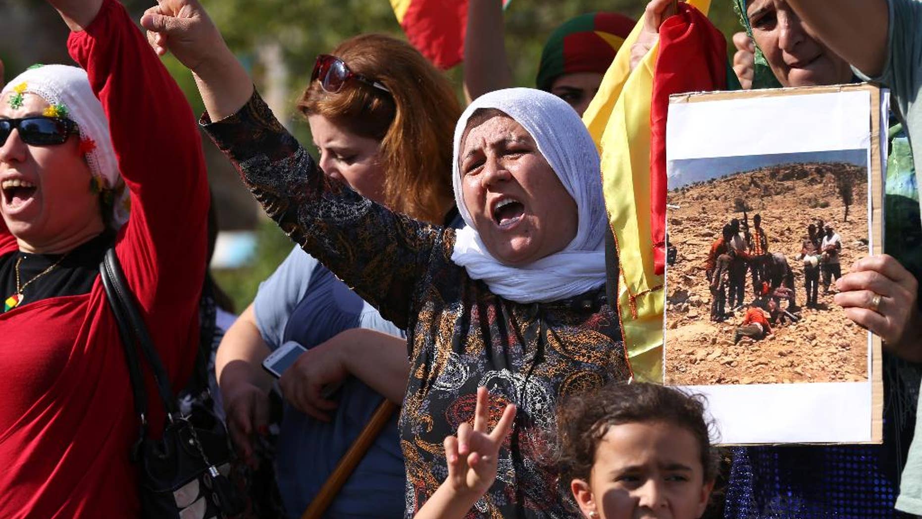 In this Sept. 15, 2014, photo, Kurdish citizens who live in Lebanon shout slogans and hold a photograph during a demonstration against militants who refer to themselves as the Islamic State, in front of the UN building, in downtown Beirut, Lebanon. Osama bin Laden is dead and al-Qaida dispersed, yet the horrors keep coming. Journalists beheaded on camera. School girls abducted by gunmen in the night. Families fleeing their homes in fear they might be executed because of their religion. The news from much of the Middle East and Africa is relentlessly brutal. The Islamic State group’s rampage through Iraq and Syria has shocked the United States into launching expanded air strikes at a time when Americans were expecting to pull back from the Middle East after more than a decade of war. (AP Photo/Hussein Malla)
