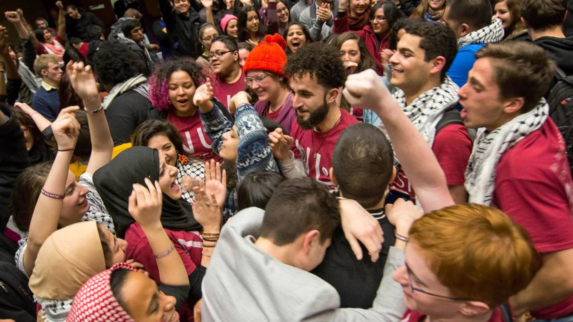 In this photo provided by the The Daily Northwestern, Northwestern University students celebrate after the Associated Student Government Senate passed a Northwestern Divest-sponsored resolution in Evanston, Ill. just before 1:30 a.m. on Thursday, Feb. 19, 2015. The resolution asks the university to divest from six corporations the resolution’s sponsors say violate Palestinians' human rights. (AP Photo/The Daily Northwestern, Nathan Richards)