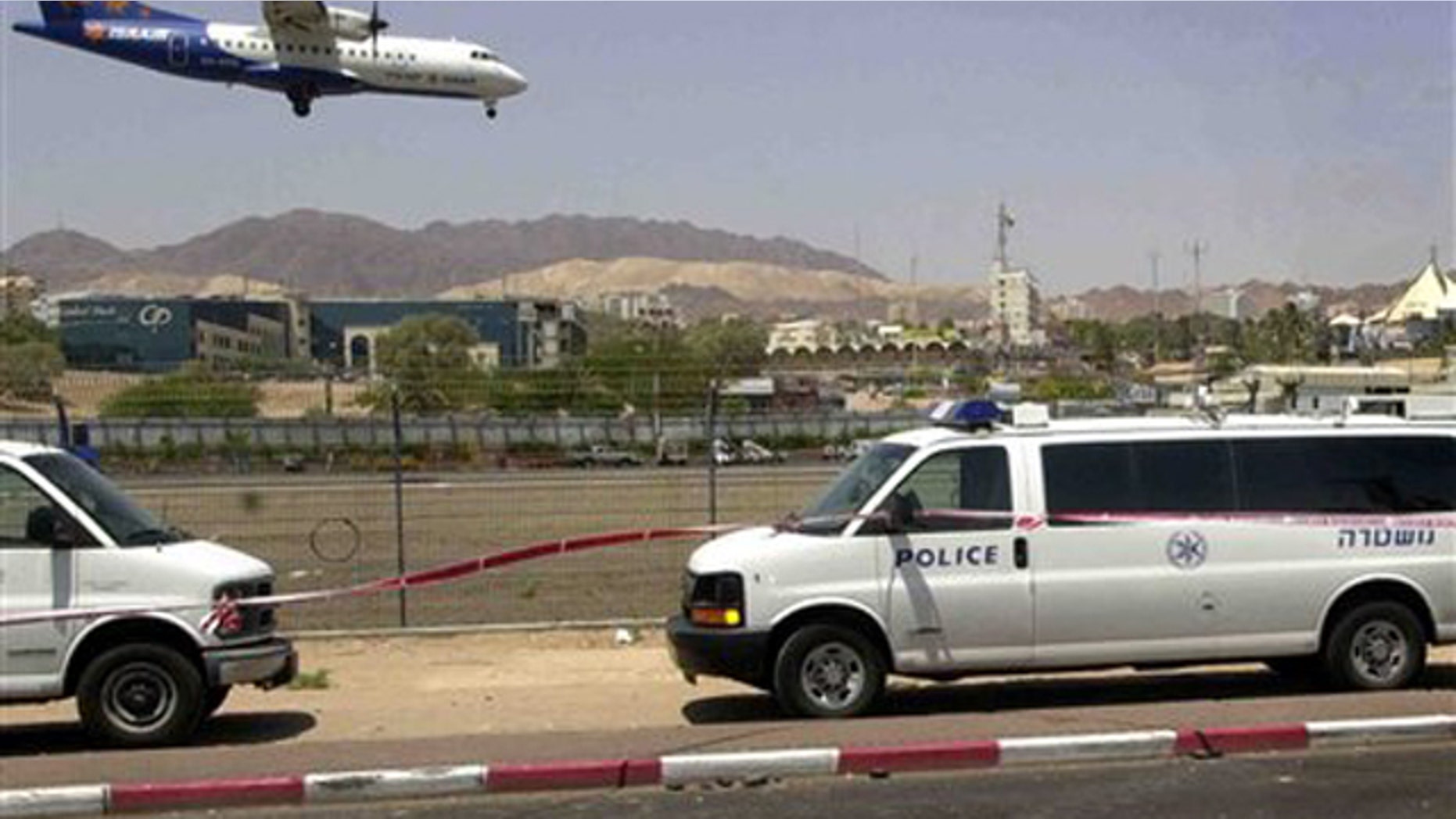 A crater left by a rocket is seen on the side of the road near the airport of southern Israel's resort town of Eilat.