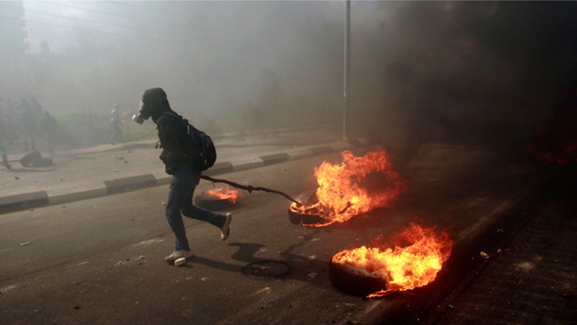 Feb. 25, 2013: A man burns tires during a protest to support Palestinian prisoners, outside Ofer, an Israeli military prison, near the West Bank city of Ramallah.