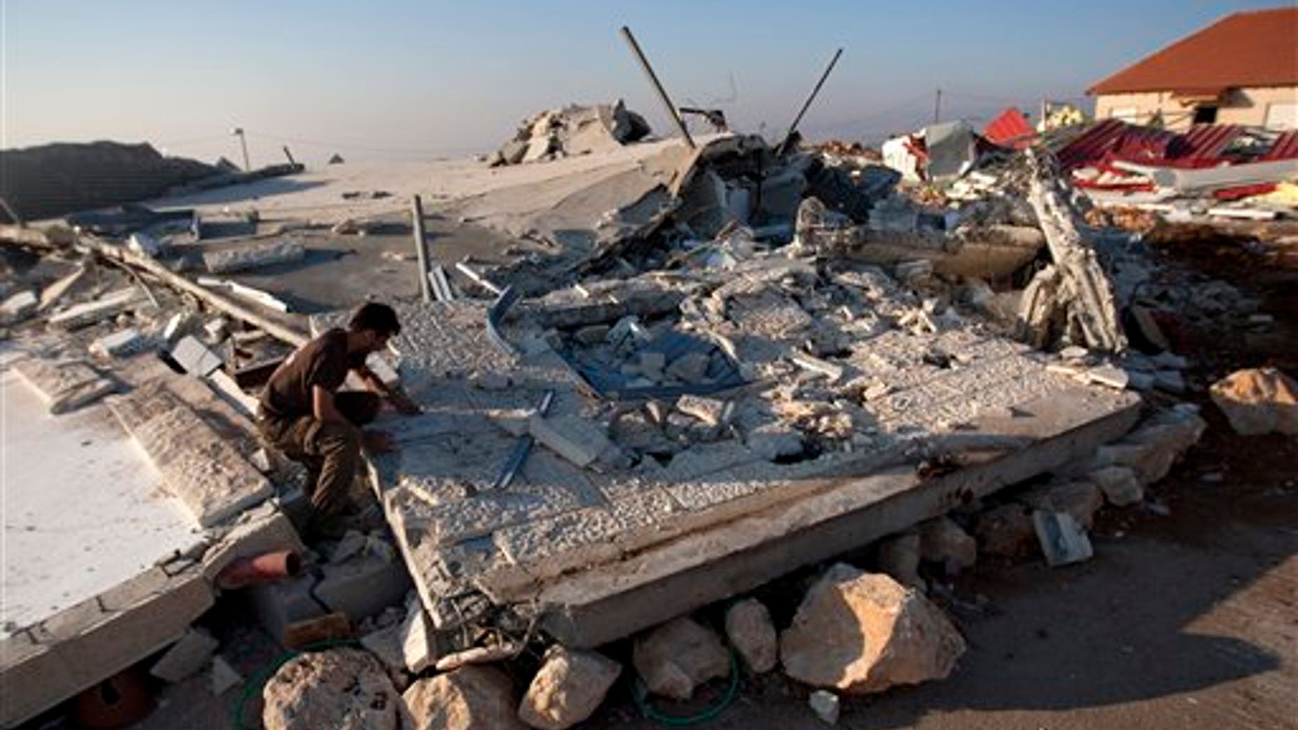 Sept. 5, 2011: A Jewish settler sits on the rubble of a house demolished by the Israeli authorities in the West Bank settlement of Migron near the Palestinian city of Ramallah.