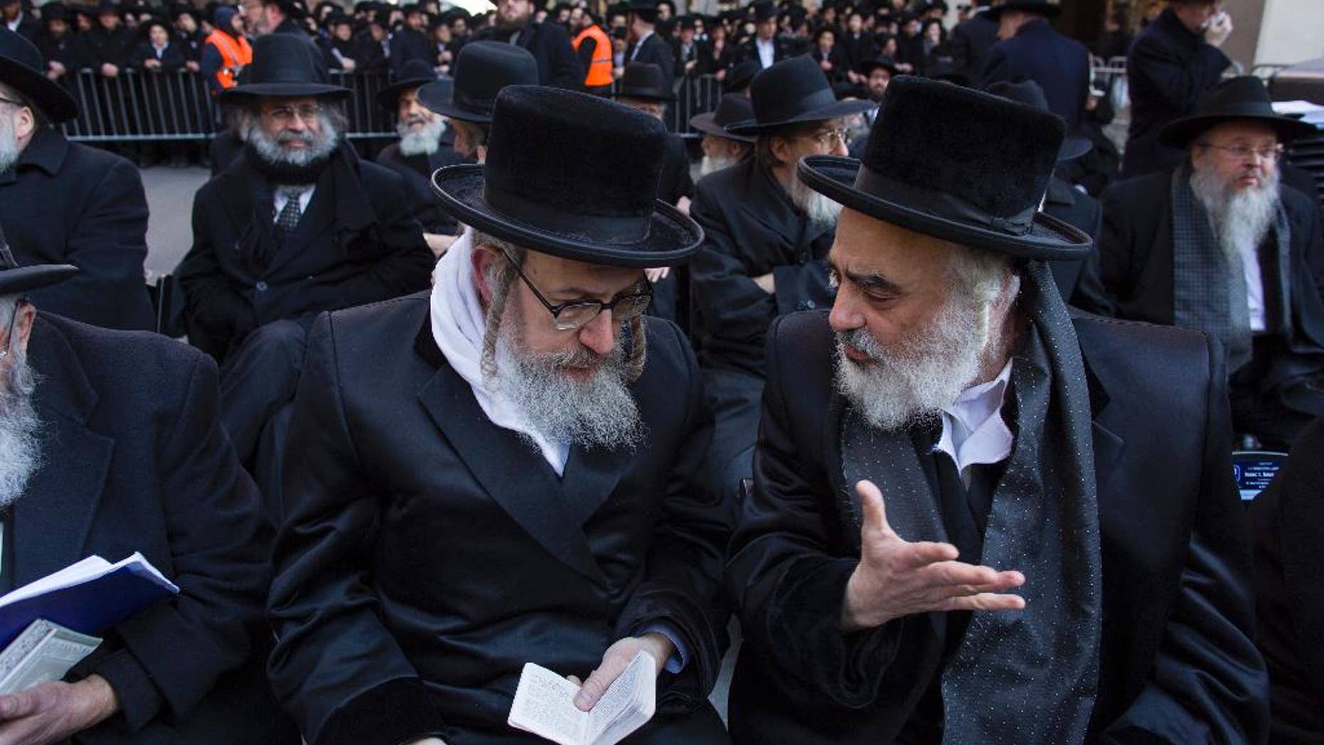 Rabbis speaks to one another as they joined other Orthodox Jews in New York, Sunday, March 9, 2014, on Water Street in lower Manhattan, to pray and protest against the Israeli government's proposal to pass a law that would draft strictly religious citizens into its army. (AP Photo/Craig Ruttle)
