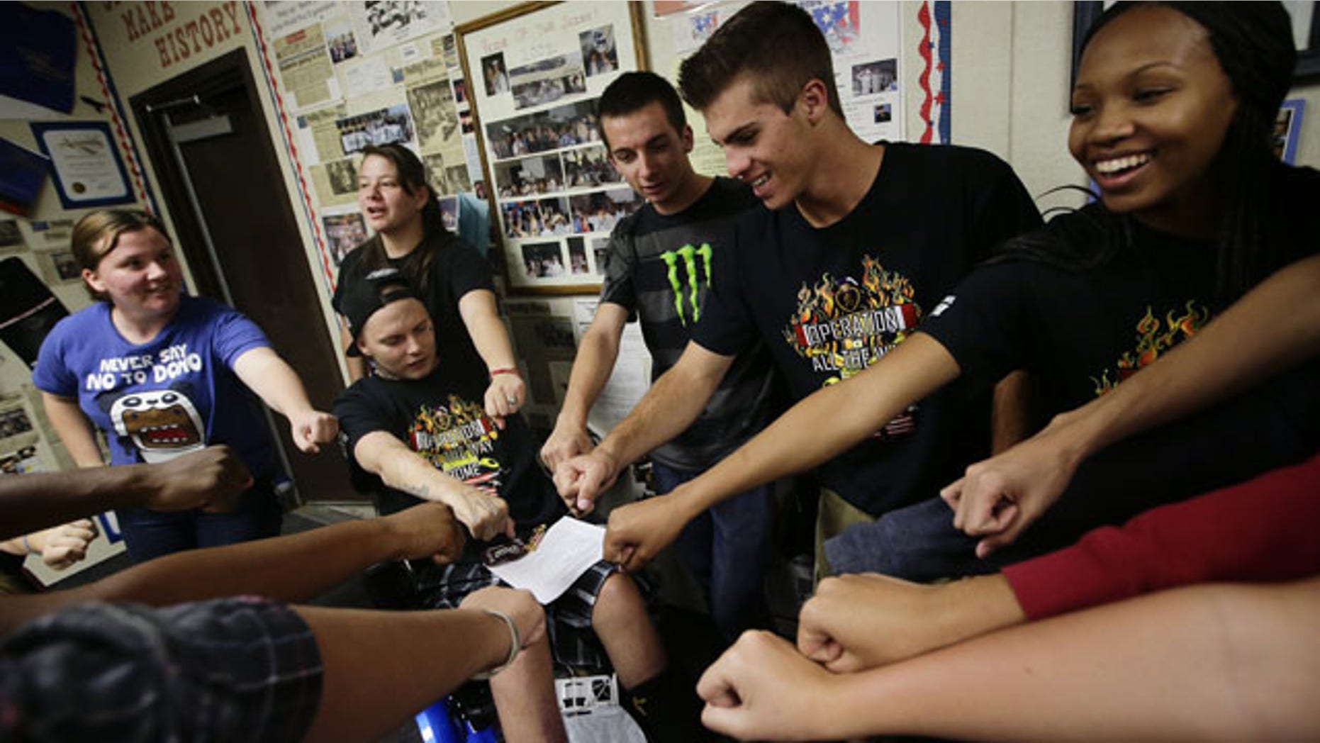 October 21, 2013: 27-year-old Iraq war veteran Jerral Hancock, sitting on an electric wheelchair, and members of Operation All The Way Home(OATH) chant their slogans after a meeting at Lancaster High School in Lancaster, Calif. The seniors in Jamie Goodreau's high school history class learned Hancock was stuck in a modest mobile home for months, unable to travel the 70 miles to the nearest VA hospital in Los Angeles to have his bedsores treated or his rotting teeth fixed. Goodreau's students, who each year raise a few thousand dollars for veterans, decided to make Hancock their cause. (AP Photo)