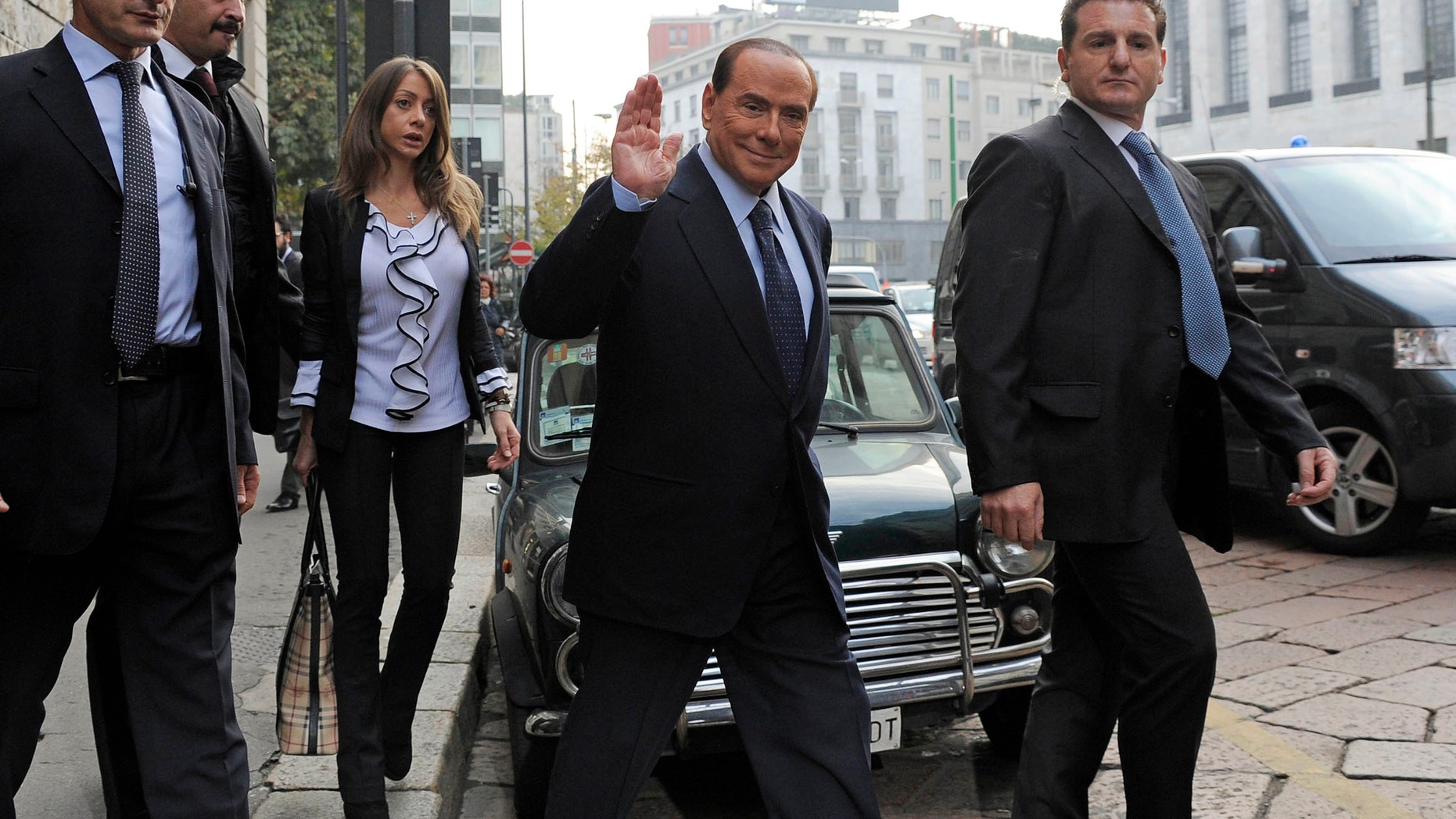 Former Italian Premier Silvio Berlusconi salutes as he arrives for a court hearing in Milan, Italy, Friday, Oct. 19, 2012. Berlusconi has denied in court having had sex with an underage Moroccan girl, or ever paying for sex with any guest at his villa near Milan, and insisted that no gathering of a sexual nature took place at his residence. Berlusconi made the remarks during a rare appearance at his ongoing trial on charges of having paid for sex with teenager Karima el-Mahroug and using his influence to cover it up. (AP Photo/Gian Mattia D'Alberto, Lapresse) ITALY OUT