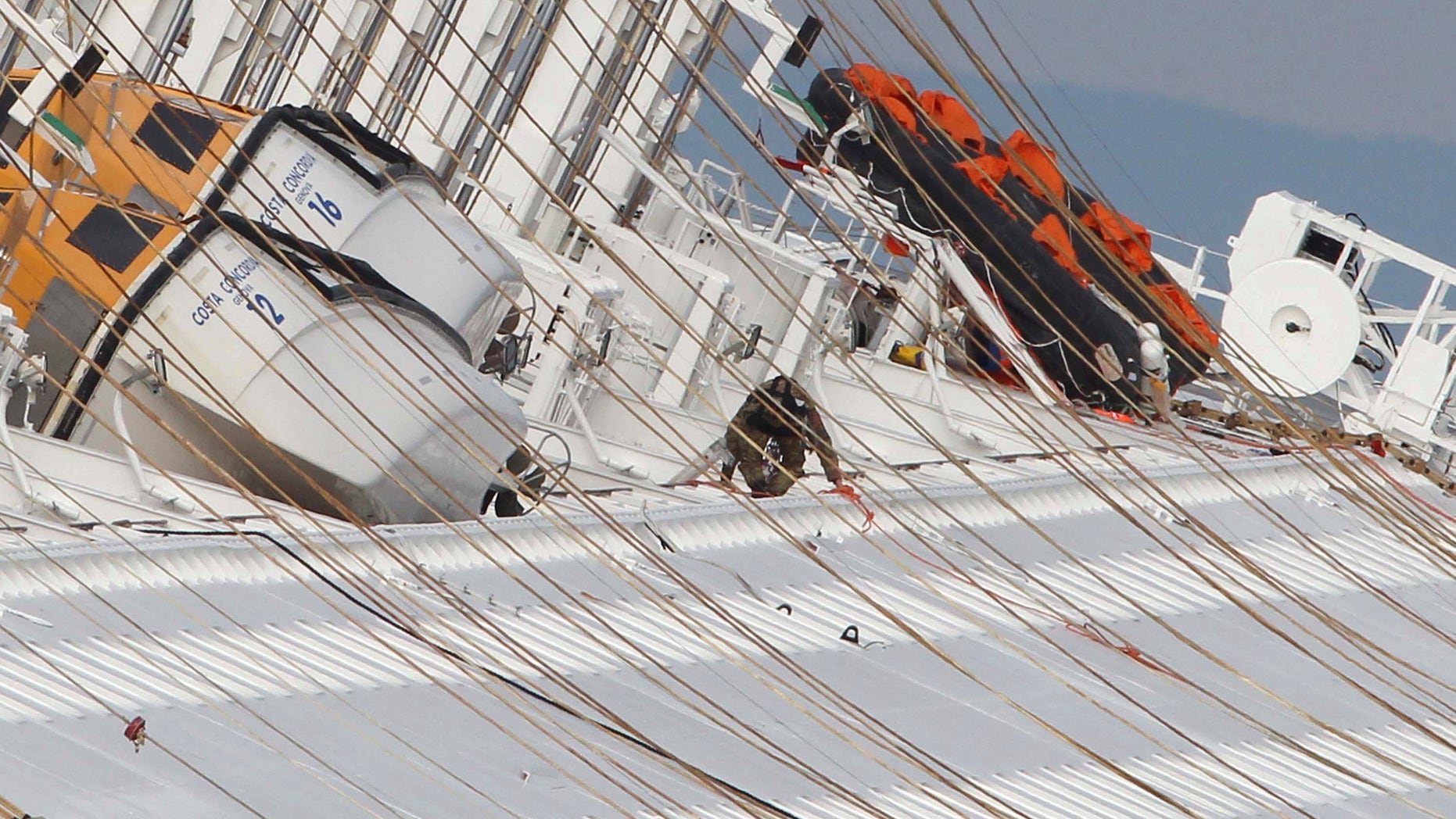 Jan. 17, 2012: An Italian navy soldier works on the cruise ship Costa Concordia after it ran aground on the tiny Tuscan island of Giglio, Italy, on Friday evening. Italian naval divers on Tuesday exploded holes in the hull of a cruise ship grounded off a Tuscan island to speed the search.