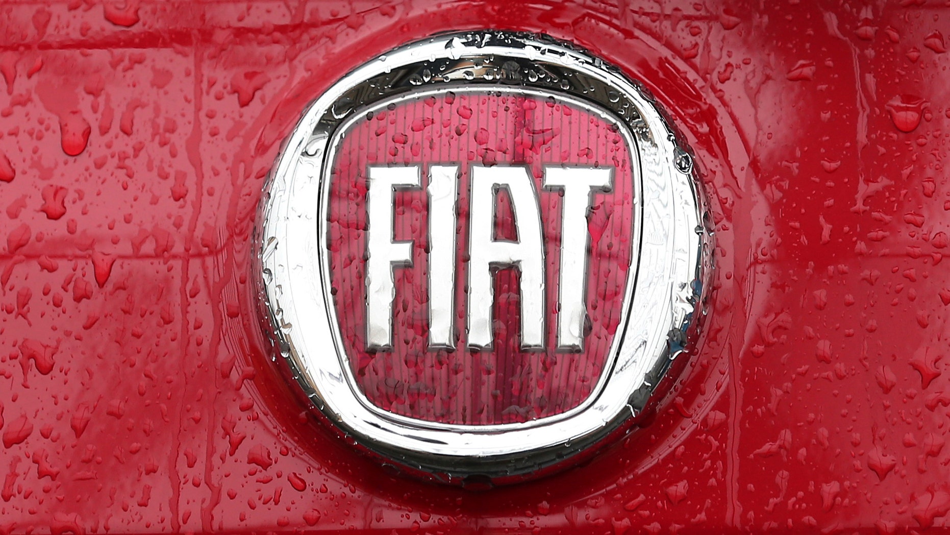 Rain falls on a Fiat logo pictured on a car in Milan, Italy, Thursday, Jan. 2, 2014. Italian automaker Fiat SpA announced that it reached an agreement to acquire the remaining shares of Chrysler for $3.65 billion in payments to a union-controlled trust fund. Fiat already owns 58.5 percent of Chrysler's shares, with the remaining 41.5 percent held by a United Auto Workers union trust fund that pays health care bills for retirees.( AP Photo/Antonio Calanni)