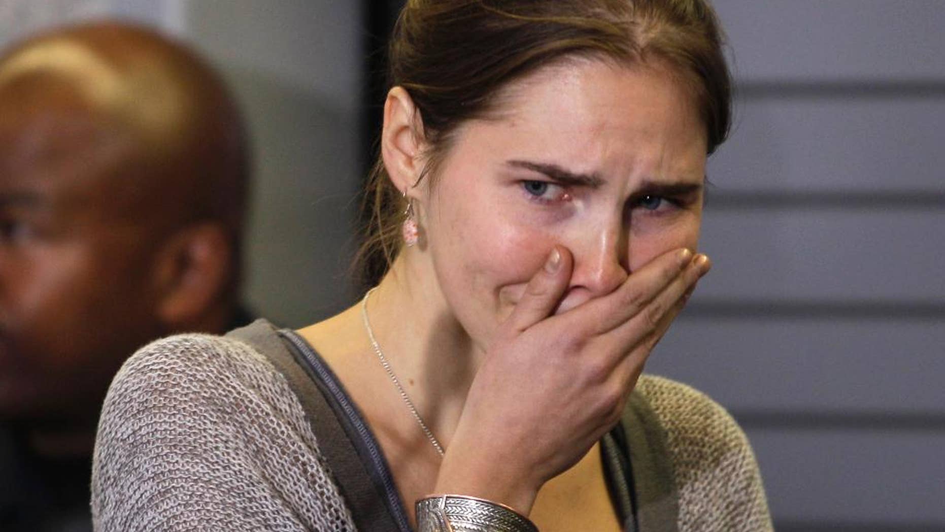 FILE - In this Tuesday, Oct. 4, 2011 file photo, Amanda Knox gestures during a press conference, in Seattle. A court in Florence that convicted Amanda Knox in her British roommate's 2007 murder says the wounds indicate multiple aggressors, and that the two exchange students fought over money the night of the murder. The appellate court on Tuesday, April 29, 2014, issued a 337-page explanation for its January guilty verdicts against Knox and her former boyfriend Raffaele Sollecito. Knox, 26, was sentenced to 28 ½ years while Sollecito, 30, received 25 years. Knox has been in the United States since 2011, when an earlier appellate trial that overturned her lower court conviction. Sollecito remains in Italy. The release of the court's reasoning opens the verdict to an appeal back to the supreme Court of Cassation. If the high court confirms the convictions, a long extradition fight for Knox is expected. Kercher, 21, was found dead in a pool of blood in the apartment she and Knox shared in the town of Perugia. (AP Photo/Ted S. Warren, File)