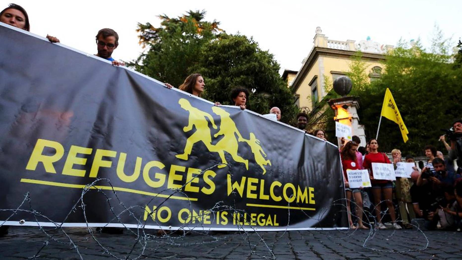 Activists hold a banner reading "Refugees Welcome, no one is illegal" in front of the Hungarian Embassy in Rome, Monday, Sept. 21, 2015, after the Hungarian government warned migrants not to enter the country as it is a crime punishable by imprisonment. Hungarian lawmakers have also approved legislation allowing the government to send troops to help police manage the migration crisis. (Fabio Campana/ANSA via AP) 5 . ANSA / FABIO CAMPANA