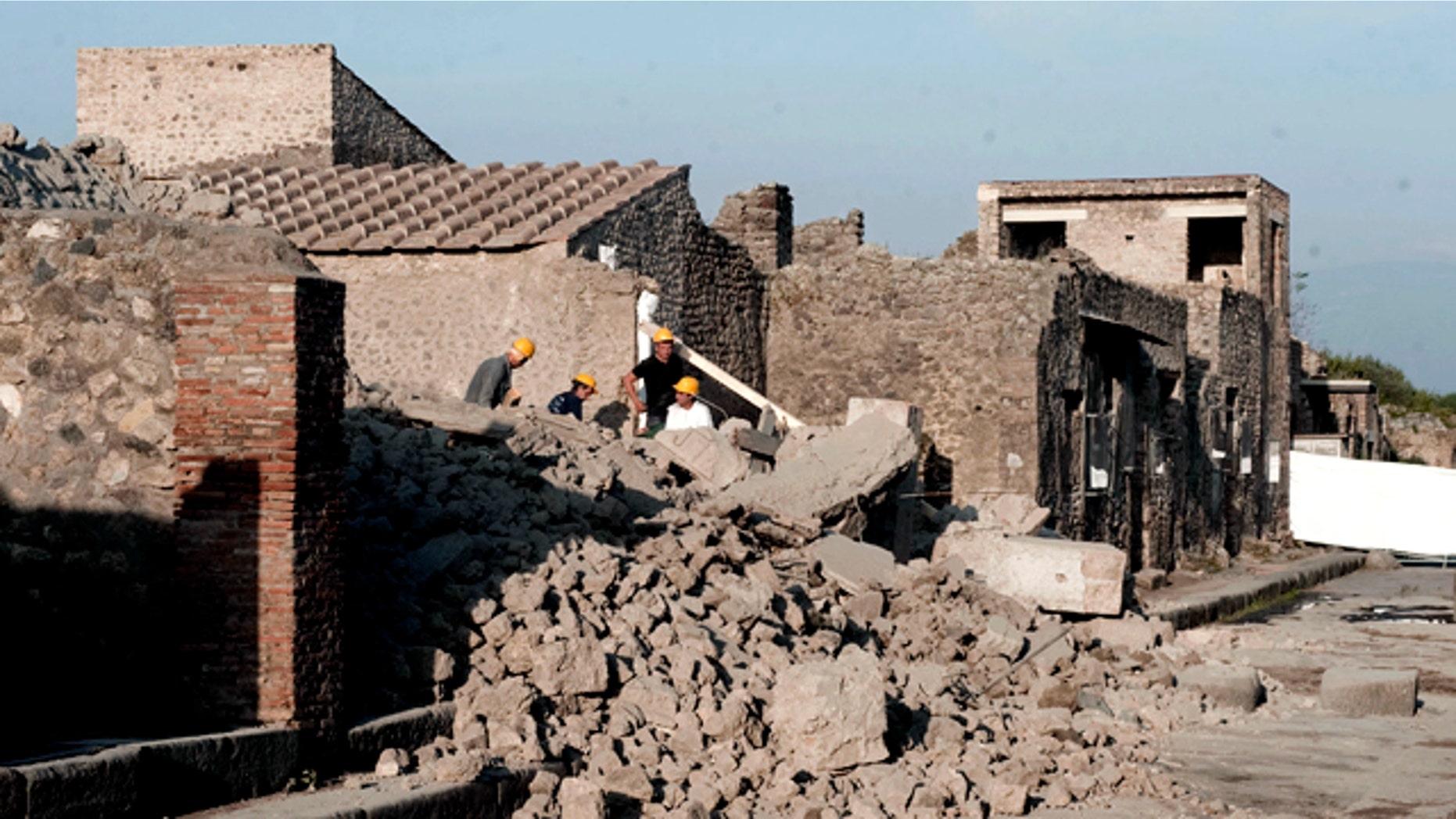 Workers stand among debris in the ancient Roman city of Pompeii, Italy, Saturday, Nov. 6, 2010. Officials say that a house in the ancient Roman city of Pompeii once used by gladiators to train before combat has collapsed. The site was closed at the time and nobody was injured. The office of Pompeii's archaeological superintendent said the collapse occurred Saturday at around 6 a.m. (0500 GMT). Attendants opening the site saw the collapse about an hour later.