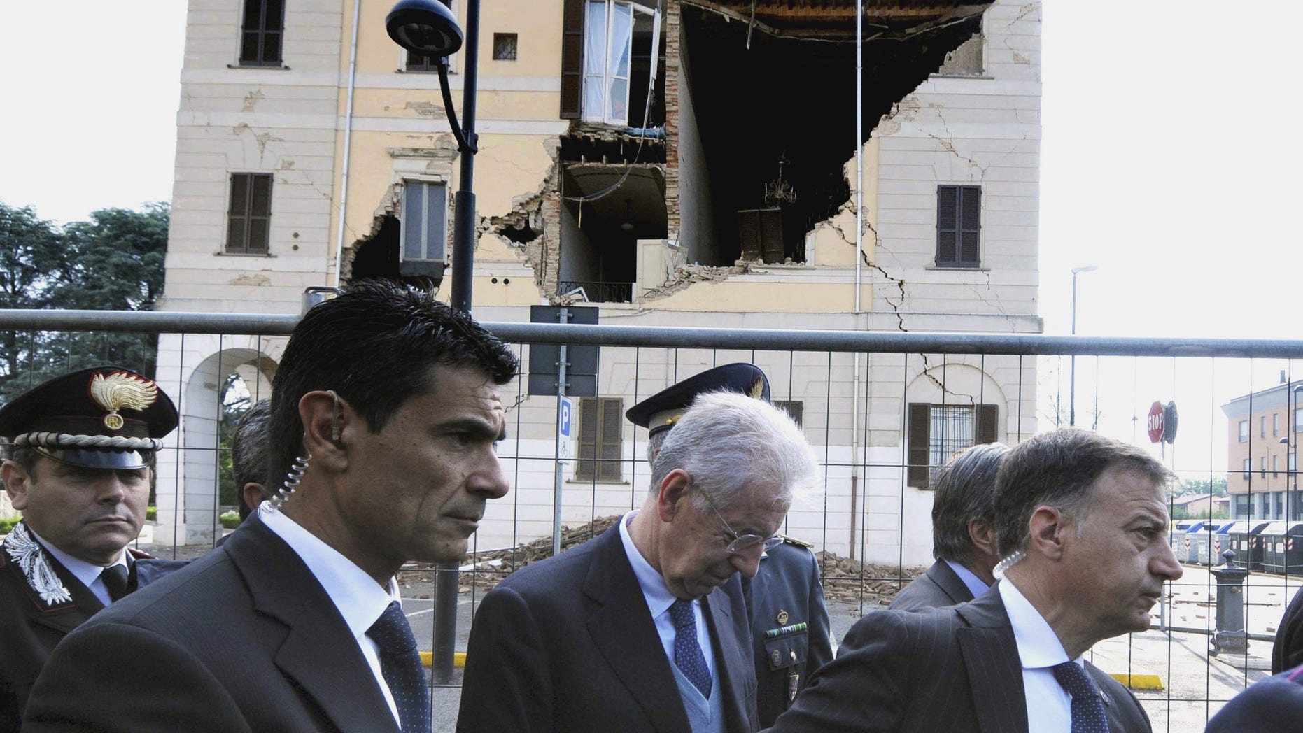 May 22, 2012: Italian Premier Mario Monti, center, looks down as he walks past the damaged town hall of Sant'Agostino, during a visit to the area hit by a quake.