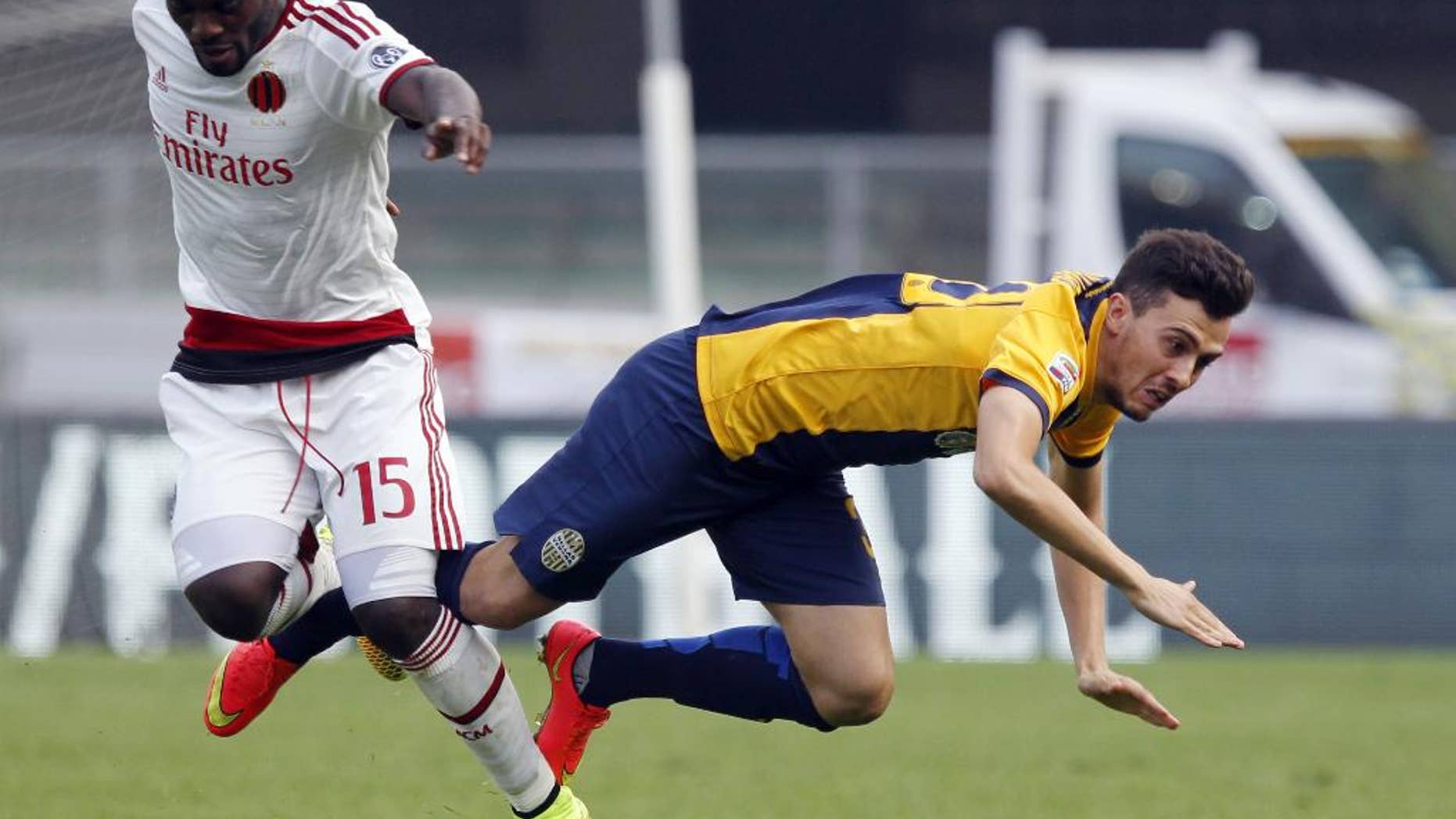 AC Milan's Michael Essien, left, fights for the ball with Hellas Verona's Gustavo Campanharo during a Serie A soccer match at the Bentegodi stadium in Verona, Italy, Sunday, Oct. 19, 2014. (AP Photo/Felice Calabro')