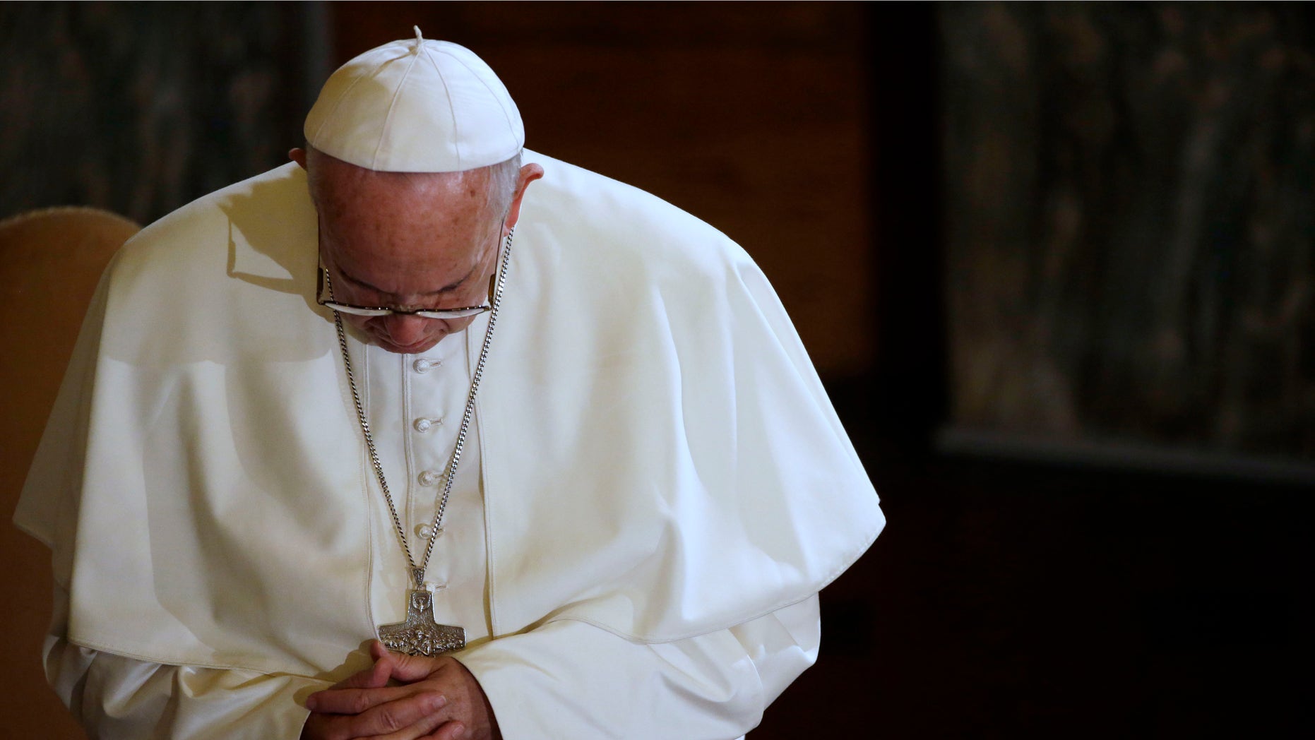 Pope Francis prays during a visit to the Lutheran church, in Rome, Sunday, Nov. 15, 2015. Pope Francis has condemned the Paris terror attacks, calling it "blasphemy" to use the name of God to justify "the road of violence and of hatred." (AP Photo/Gregorio Borgia)