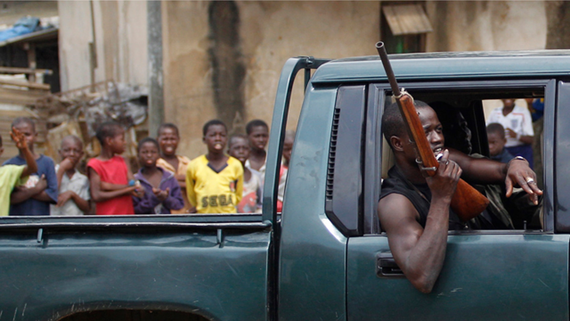 March 12: Children look on as a fighter opposed to Laurent Gbagbo passes in a pick-up truck, in the Anyama neighborhood of Abidjan, Ivory Coast
