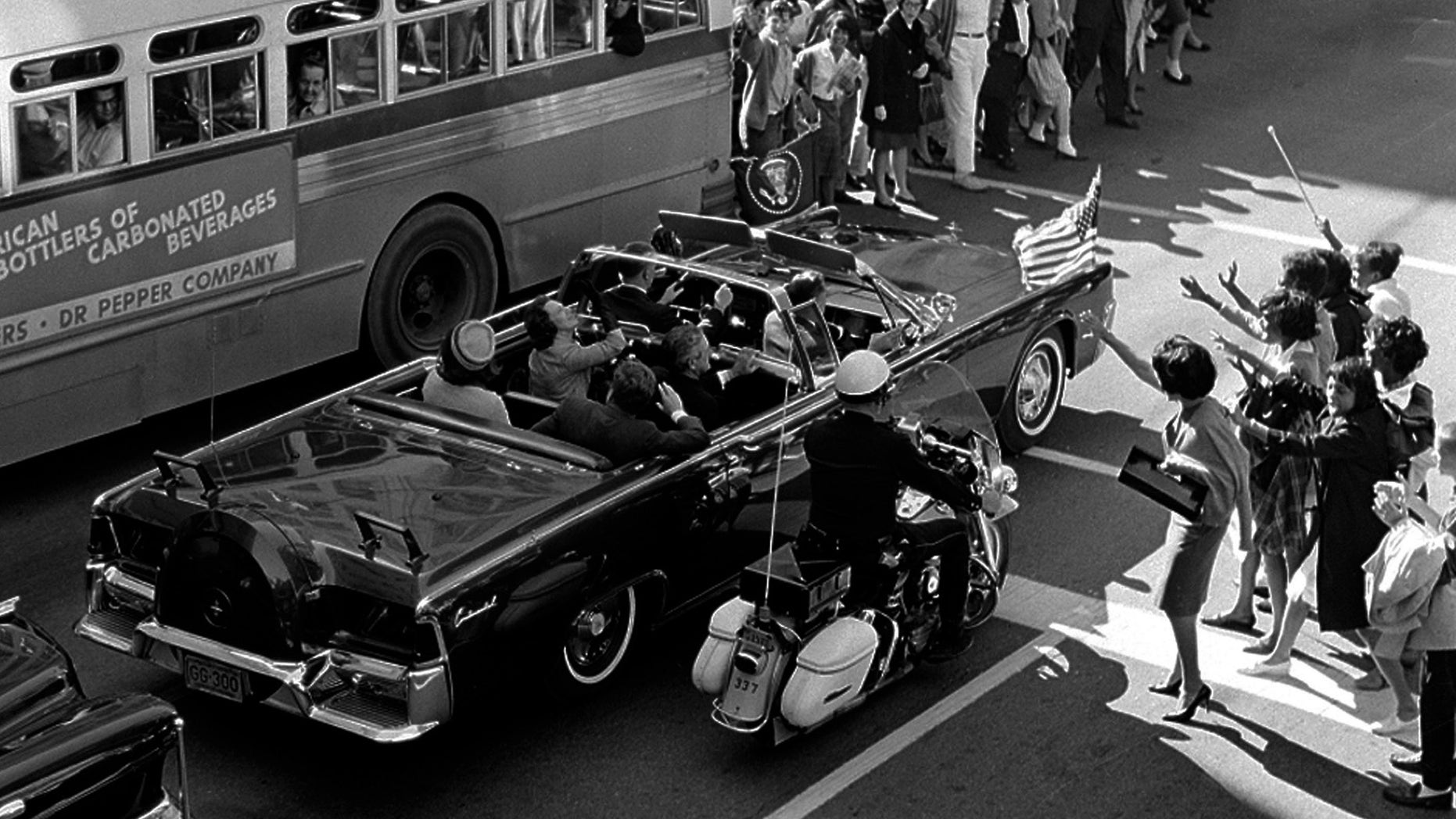 In this Nov. 22, 1963 file photo, President John F. Kennedy and first lady Jacqueline Kennedy ride in the backseat of an open limousine on Main Street at Ervay Street in Dallas as the presidential motorcade approaches Dealey Plaza.