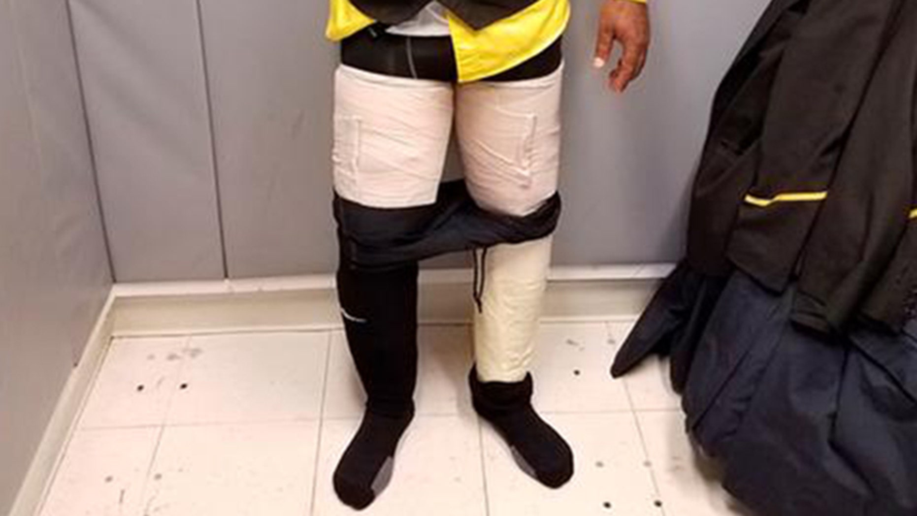 Customs officers discovered four packages containing white powder taped to an airline crew member's legs.