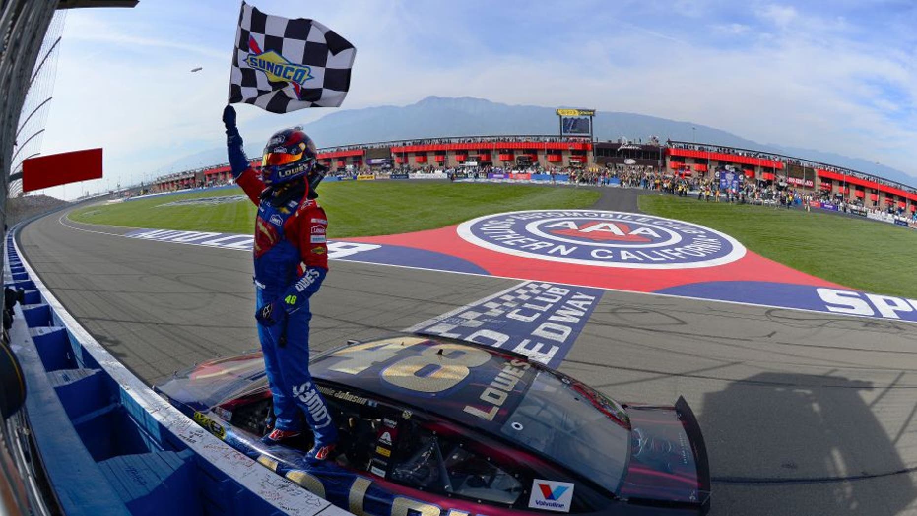 FONTANA, CA - MARCH 20: Jimmie Johnson, driver of the #48 Lowe's / Superman Chevrolet, celebrates after taking the checkered flag during the NASCAR Sprint Cup Series Auto Club 400 at Auto Club Speedway on March 20, 2016 in Fontana, California. (Photo by Robert Laberge/Getty Images)