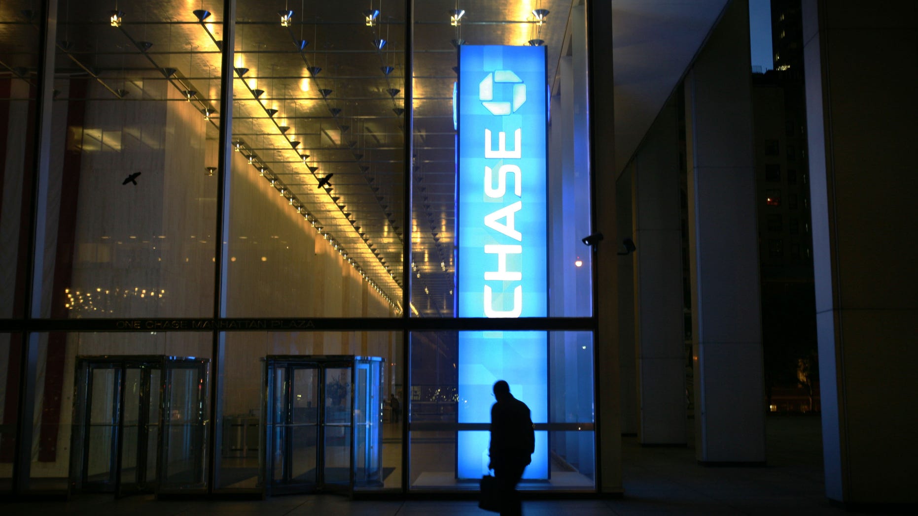 FILE - In this Oct. 10, 2008 file photo, a man walks into a JPMorgan Chase & Co. building in New York's financial district. Since the financial crisis, JPMorgan Chase has a long list of legal challenges beyond the $6 billion trading loss known as the "London Whale" . (AP Photo/Mark Lennihan, file)