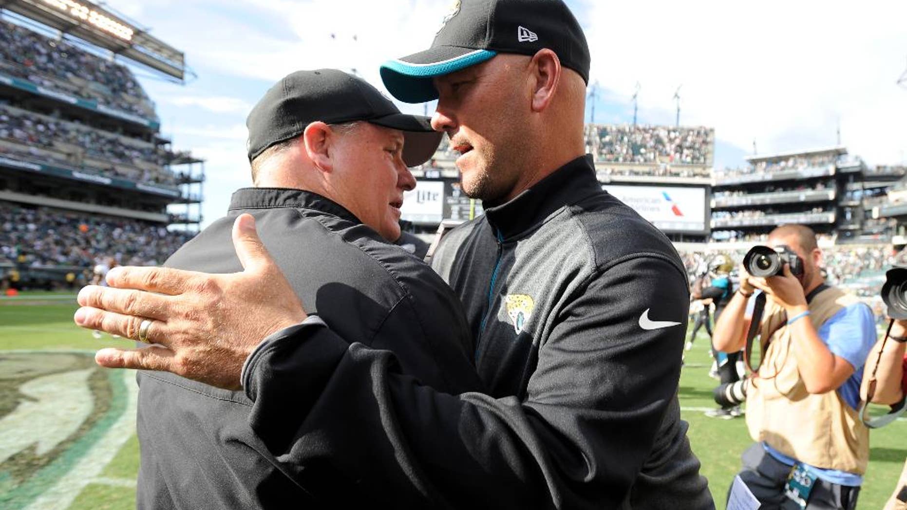 Philadelphia Eagles head coach Chip Kelly, left, and Jacksonville Jaguars head coach Gus Bradley meet after an NFL football game, Sunday, Sept. 7, 2014, in Philadelphia. Philadelphia won 34-17. (AP Photo/Michael Perez)
