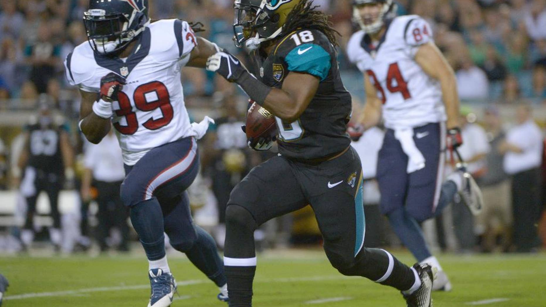 FILE - In this Dec. 5, 2013, file photo, Jacksonville Jaguars wide receiver Ace Sanders (18) returns a punt for yardage as he is chased by Houston Texans tight end Jake Byrne (89) and Ryan Griffin (84) during the first half of an NFL football game in Jacksonville, Fla. Sanders returns Sunday, Oct. 5, 2014, after missing the first four games of the season for violating the league's substance-abuse policy.(AP Photo/Phelan M. Ebenhack, File)