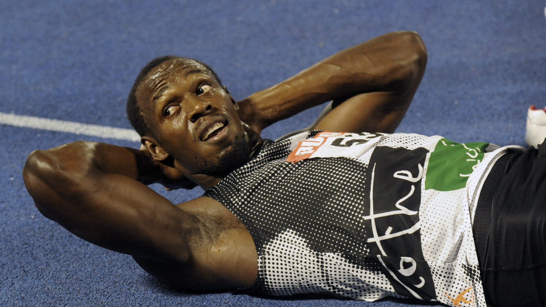 July 1, 2012: World-record holder Usain Bolt looks at the crowd while getting his right hamstring stretched out after loosing to fellow country man Yohan Blake in the 200m final at Jamaica's Olympic trials in Kingston, Jamaica.