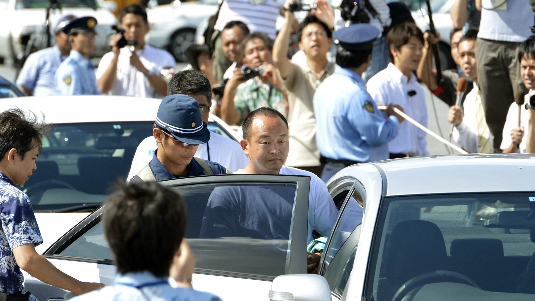 Aug. 16, 2012: An activist, center, is transferred after being arrested for landing on a set of islets known as Senkaku in Japanese and Diaoyu in Chinese, at a port in Naha, Okinawa prefecture, southern Japan.