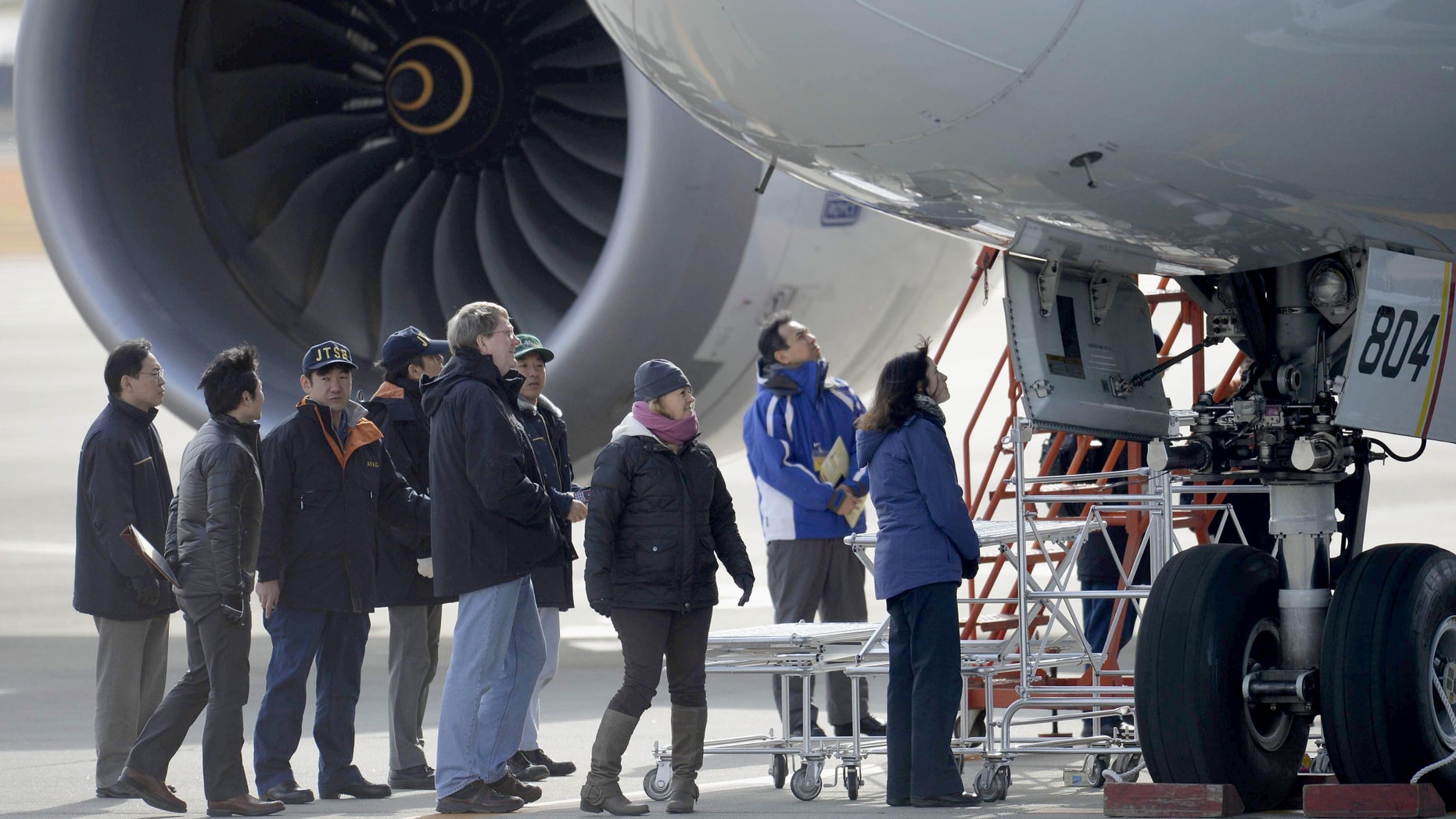 Jan. 18, 2013 - U.S. officials, center, inspect All Nippon Airways jet which made an emergency landing Wednesday, at an airport in Takamatsu, Japan.