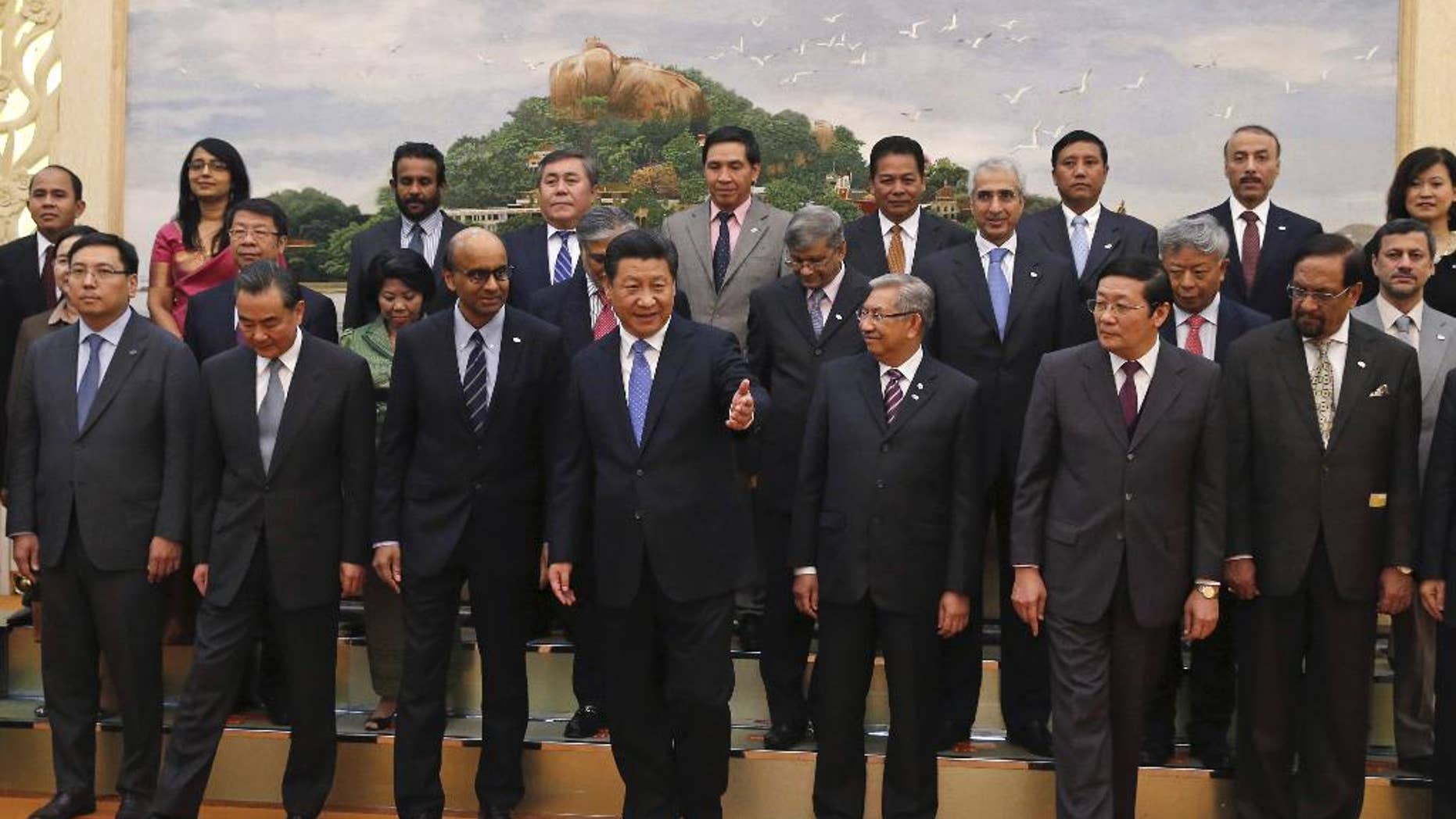 FILE - In this Friday, Oct. 24, 2014 file photo, Chinese President Xi Jinping, center, shows the way to the guests who attended the signing ceremony of the Asian Infrastructure Investment Bank at the Great Hall of the People in Beijing. Japan has no plan as of now to join the China-led Asian Infrastructure Investment Bank, its government spokesman said Tuesday, March 31, 2015. (AP Photo/Takaki Yajima, Pool, File)