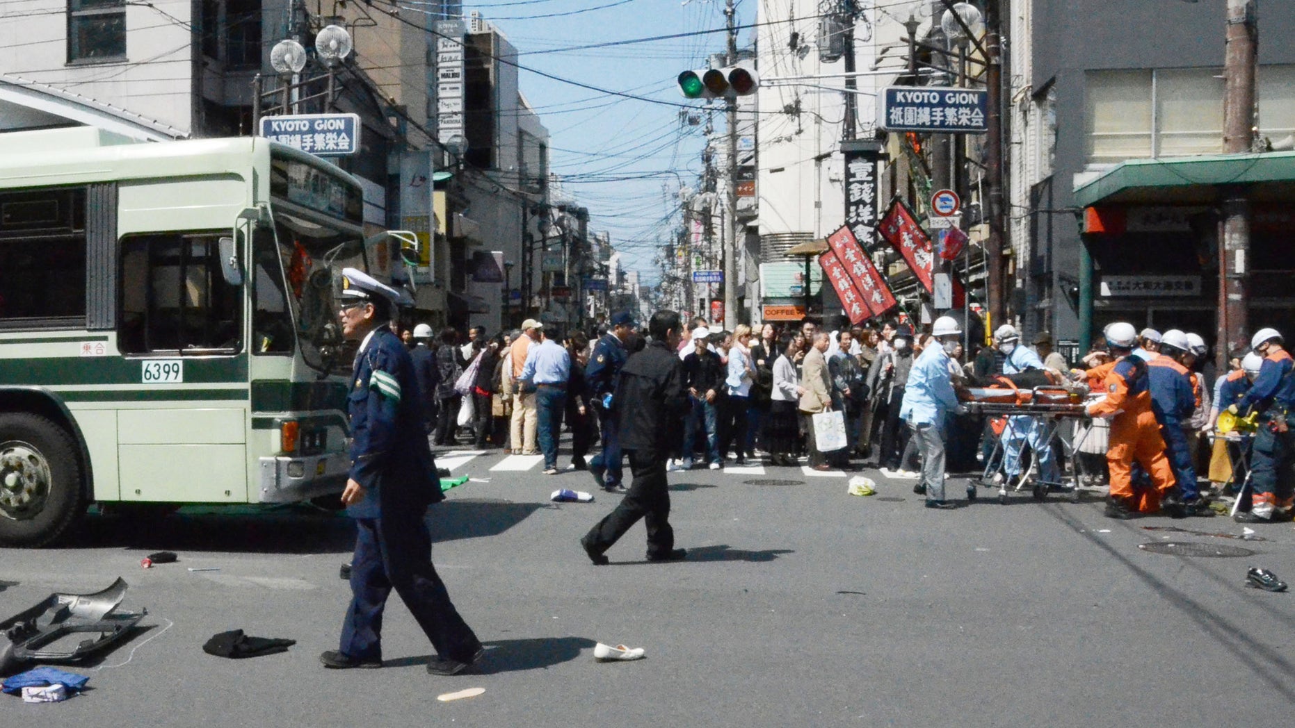 Rescue workers carry an injured person after a car went amok in the Gion district of Kyoto, western Japan, crowded with tourists and cherry blossom viewers Thursday, April 12, 2012. More than a dozen pedestrians were injured, some critically, in the tragedy. (AP Photo/Kyodo News) JAPAN OUT, MANDATORY CREDIT, NO LICENSING IN CHINA, HONG KONG, JAPAN, SOUTH KOREA AND FRANCE