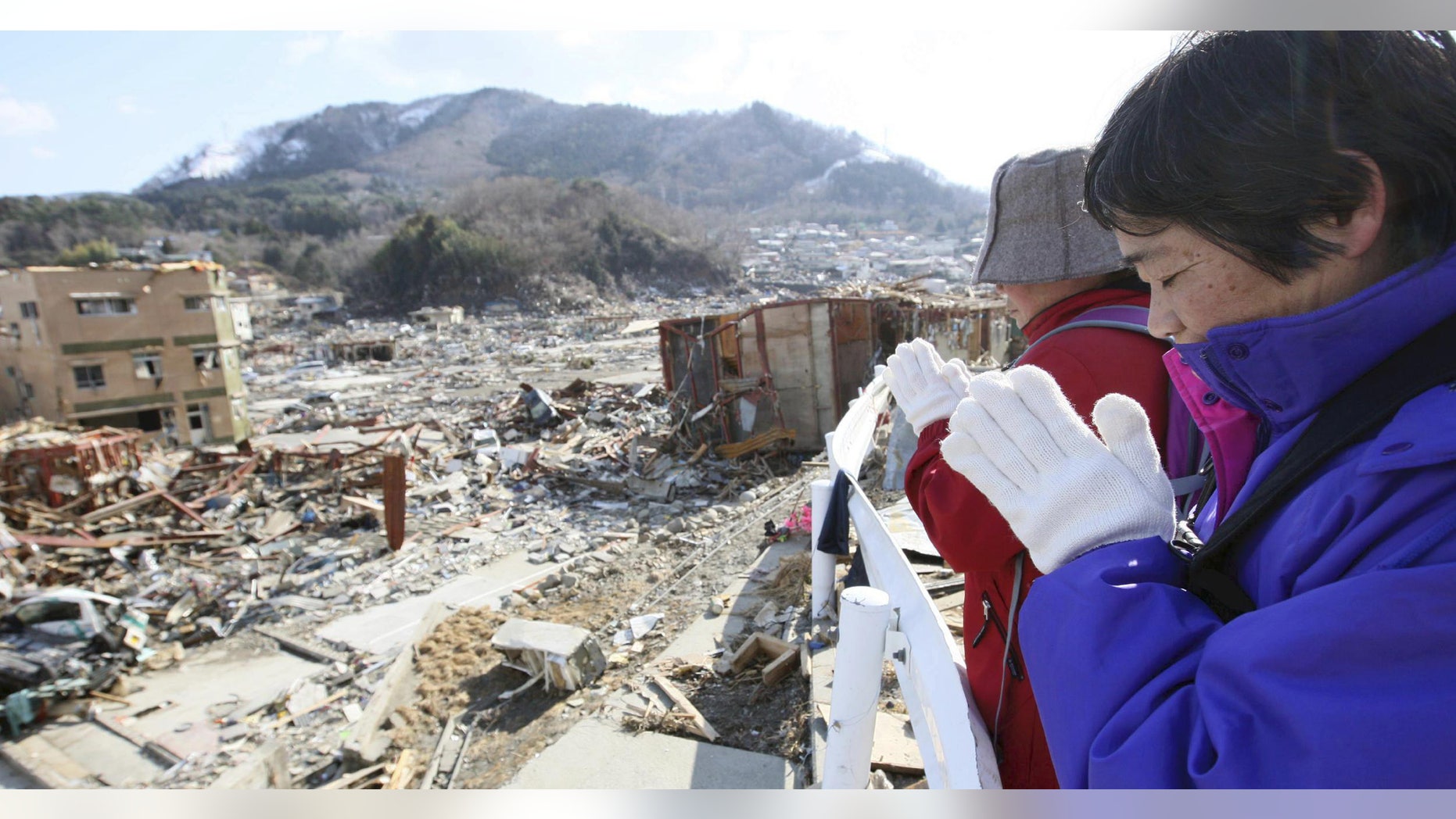 Survivors press their hands together in prayer to mourn their relatives at the devastated town of Onagawa, northeastern Japan, on Friday, March 18, 2011, just one week after a massive earthquake and resulting tsunami.