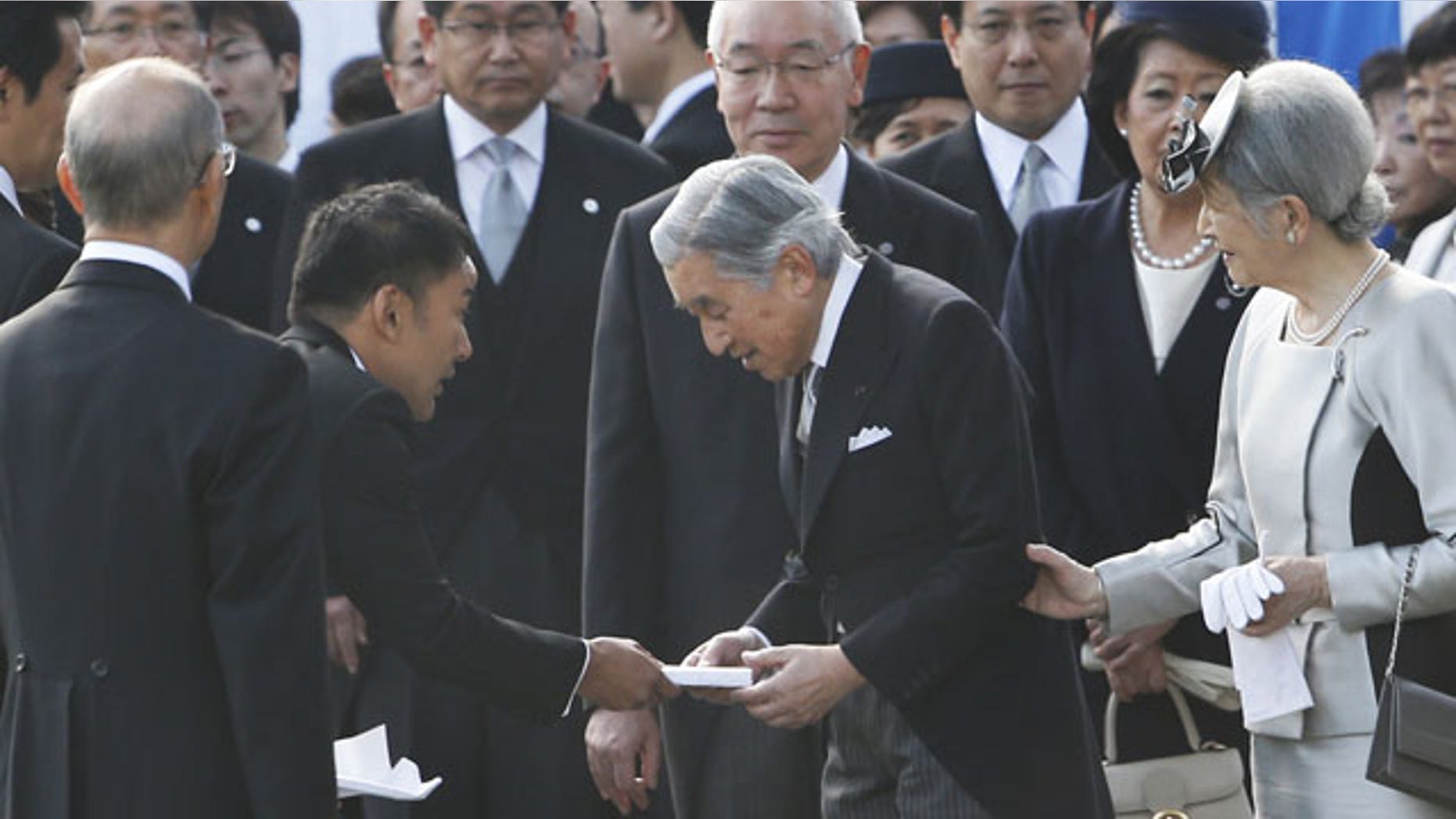 FILE - In this Thursday, Oct. 31, 2013 file photo, actor-turned-lawmaker Taro Yamamoto, second left, hands over a letter to Japan's Emperor Akihito, second right, as Empress Michiko, right, and chief steward Yutaka Kawashima, top center, look on during the autumn garden party at the Imperial Palace in Tokyo. The novice lawmaker has caused an uproar in Japan by doing something taboo: handing a letter to the emperor - a gesture considered both impolite and inappropriate. (AP Photo)