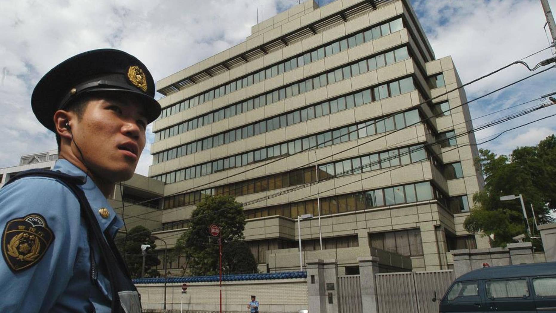 FILE - In this Wednesday, Sept. 10, 2003 file photo, a Japanese police officer is on patrol in front of the headquarters of the pro-Pyongyang General Association for Korean Residents in Japan, in Tokyo. Japan approved easing its sanctions on North Korea on Friday in response to Pyongyang's reopening of a probe into the fate of at least a dozen Japanese allegedly abducted to the North decades ago. Officials of Chongryong, or the General Association of Korean Residents in Japan, which serves as a de-facto North Korean embassy here, can obtain re-entry permits after traveling to North Korea. (AP Photo/Katsumi Kasahara, File)