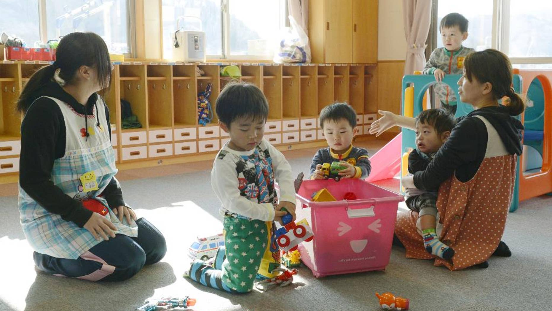 Toddlers play at a nursery school in Tamura, Fukushima Prefecture, northeastern Japan, Tuesday, April 1, 2014 after authorities allowed residents to return to live in their homes within a tiny part of a 20-kilometer (12-mile) evacuation zone around the Fukushima plant for the first time since Japan's nuclear disaster three years ago. The decision, which took effect Tuesday, applies to 357 people in 117 households from a corner of Tamura city after the government determined that radiation levels are low enough for habitation. (AP Photo/Kyodo News) JAPAN OUT, MANDATORY CREDIT