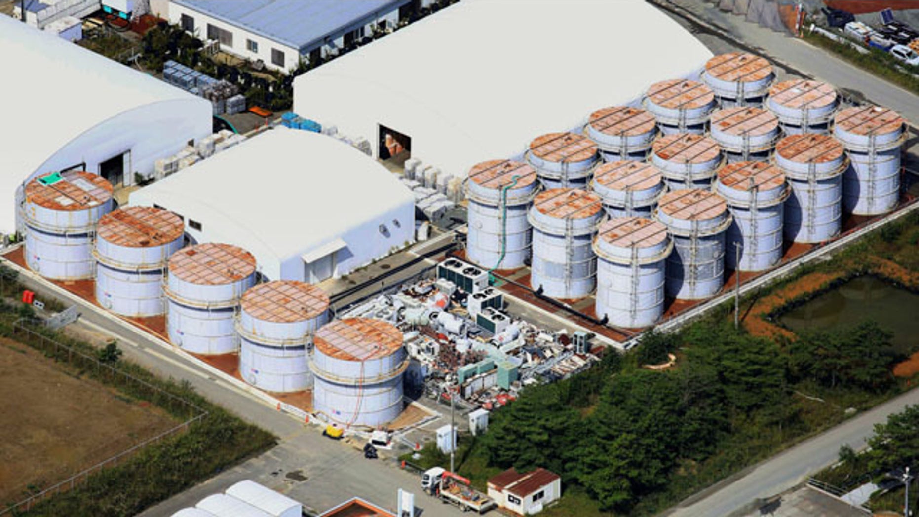 October 3, 2013: This aerial photo shows the storage tank, fifth from left at left plot, which workers detected the water dripping from the top, at the Fukushima Dai-ichi nuclear plant at Okuma town in Fukushima prefecture. (AP Photo)