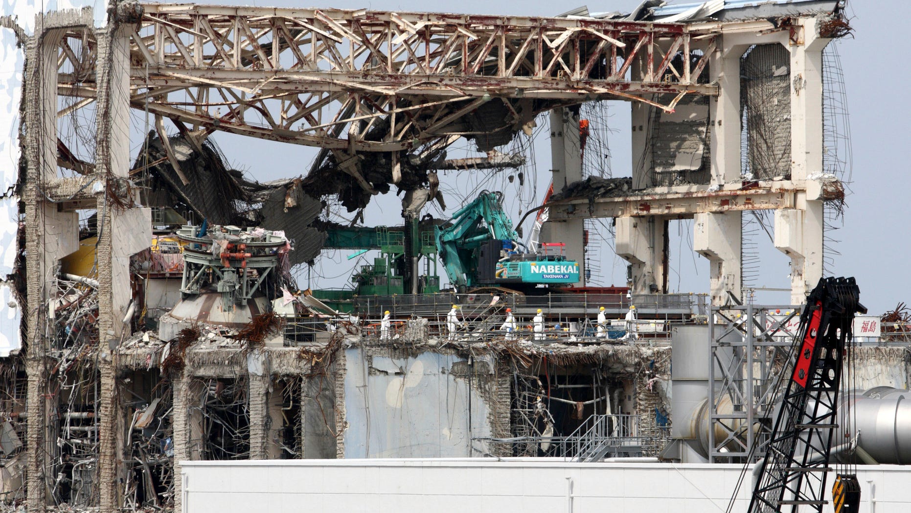 May 26, 2012: Goshi Hosono, Japan's environment and nuclear minister, third from left, wearing a red helmet, along with members of the media, walks on the No. 4 reactor building at Tokyo Electric Power Co.'s (TEPCO) Fukushima Dai-ichi nuclear power plant in Okuma, Fukushima prefecture, Japan.