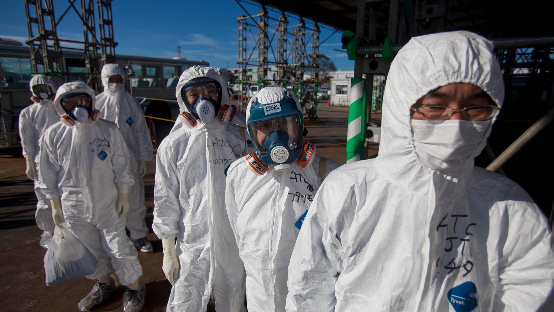 Nov. 12, 2011: In this file photo, workers in protective suits and masks wait to enter the emergency operation center at the crippled Fukushima Dai-ichi nuclear power station in Okuma, Japan.