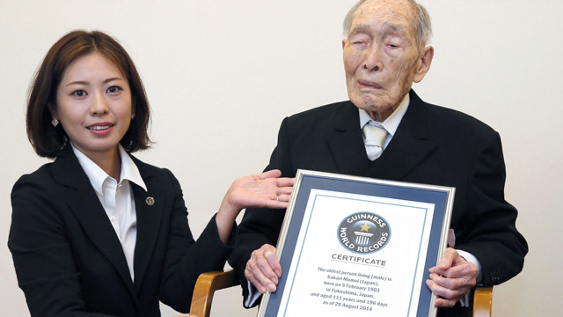 August 20, 2014: Sakari Momoi, a 111-year-old Japanese retired educator, poses for a photo after receiving a certificate from a Guinness World Records official, left, in Tokyo. Momoi was recognized as the worlds oldest living man on Wednesday, succeeding Alexander Imich of New York, who died in April at the age of 111 years, 164 days. (AP Photo/Kyodo News)