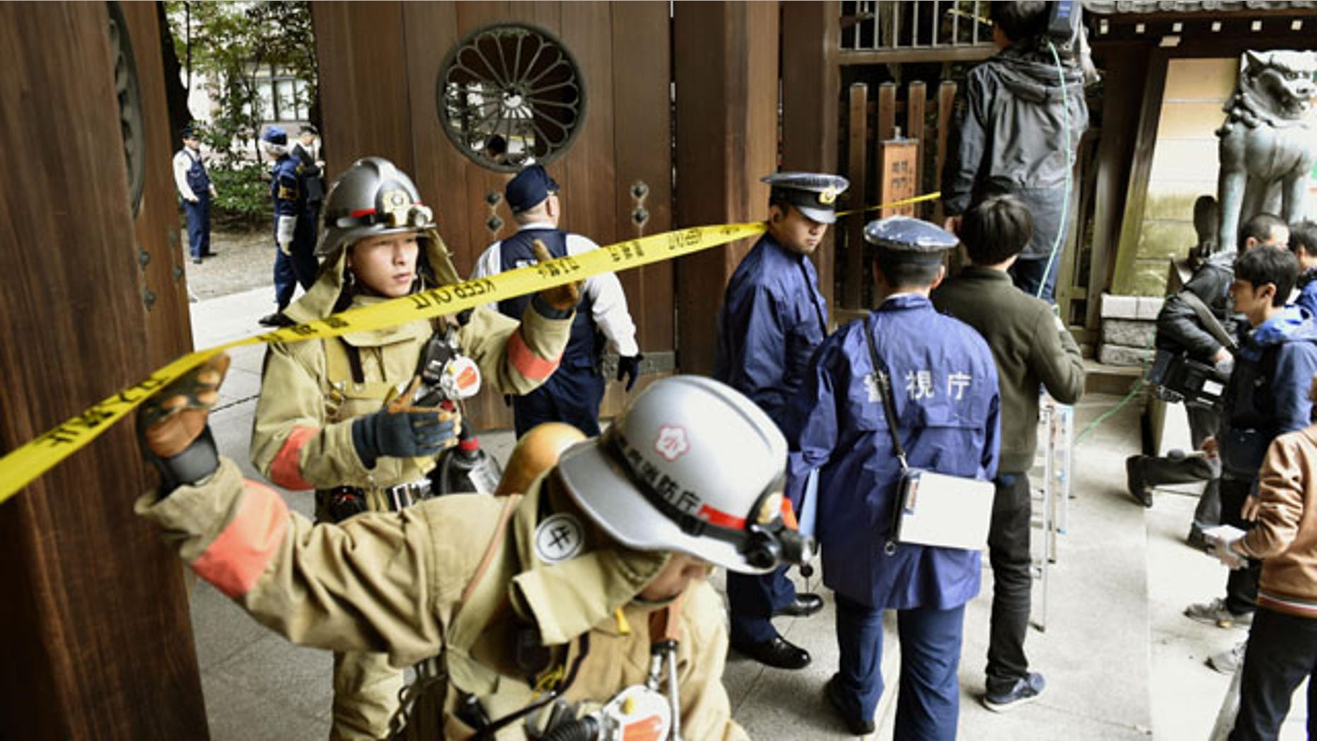 Nov. 23, 2015: Firefighters and police officers inspect around the south gate of Yasukuni shrine in Tokyo after an explosion was reported. No one was injured. (Shigeyuki Inakuma/Kyodo News via AP)