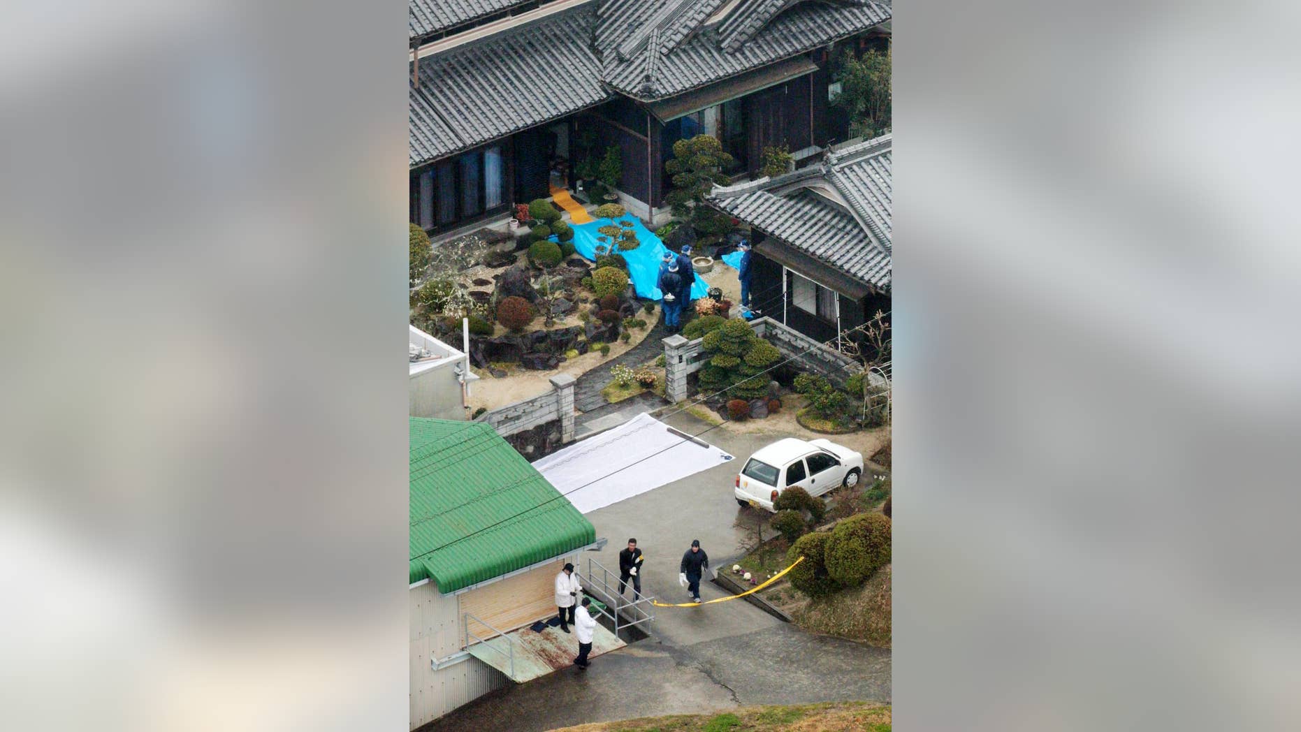 Police inspect a house where a stabbing murder took place in Sumoto, Hyogo prefecture, Monday, March 9, 2015. Police say five people have been killed in a stabbing spree in a small town in western Japan. A 40-year-old man has been arrested in connection with the Monday morning attacks.(AP Photo/Kyodo ews) JAPAN OUT, MANDATORY CREDIT