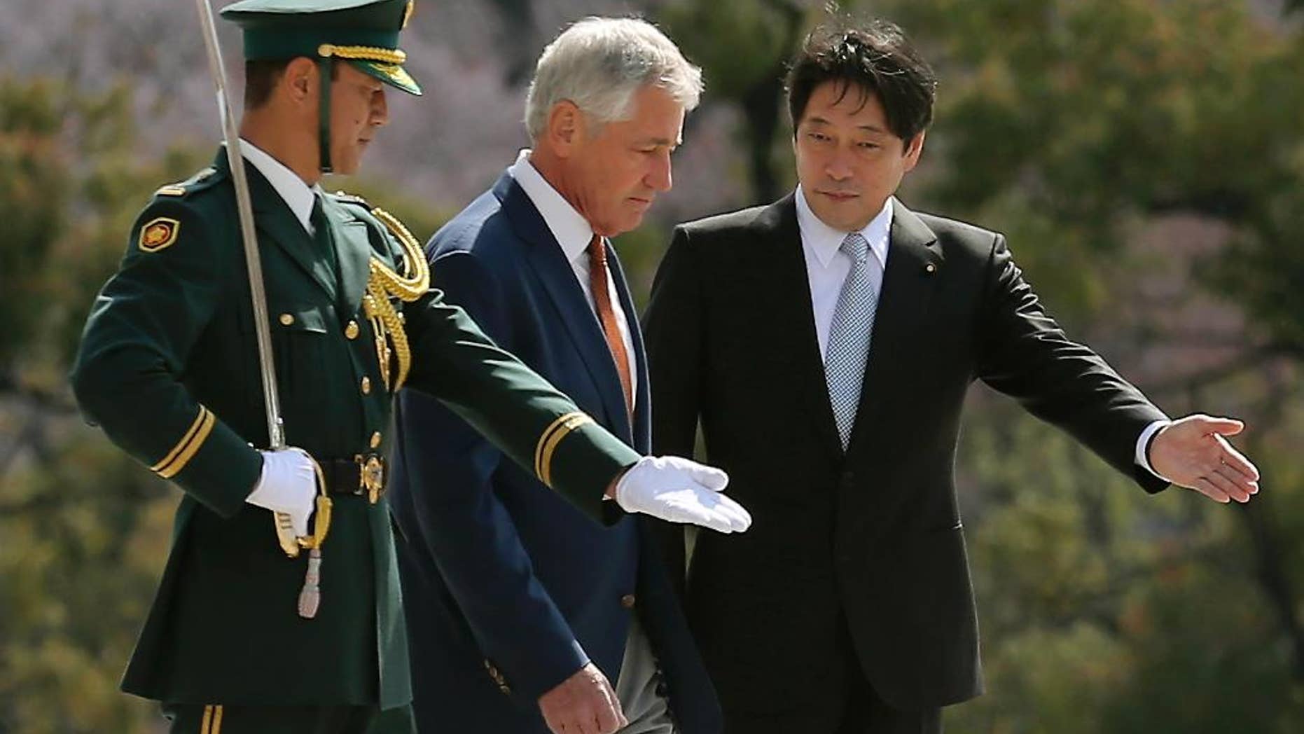 U.S. Secretary of Defense Chuck Hagel, center, is escorted by his Japanese counterpart Itsunori Onodera, right, as they inspect an honor guard at the Defense Ministry in Tokyo, Sunday, April 6, 2014. Against the backdrop of Russia's takeover of Ukraine's Crimean region, Hagel said Saturday he will convey to Japanese leaders that the U.S. is strongly committed to protecting their country's security. (AP Photo/Eugene Hoshiko)